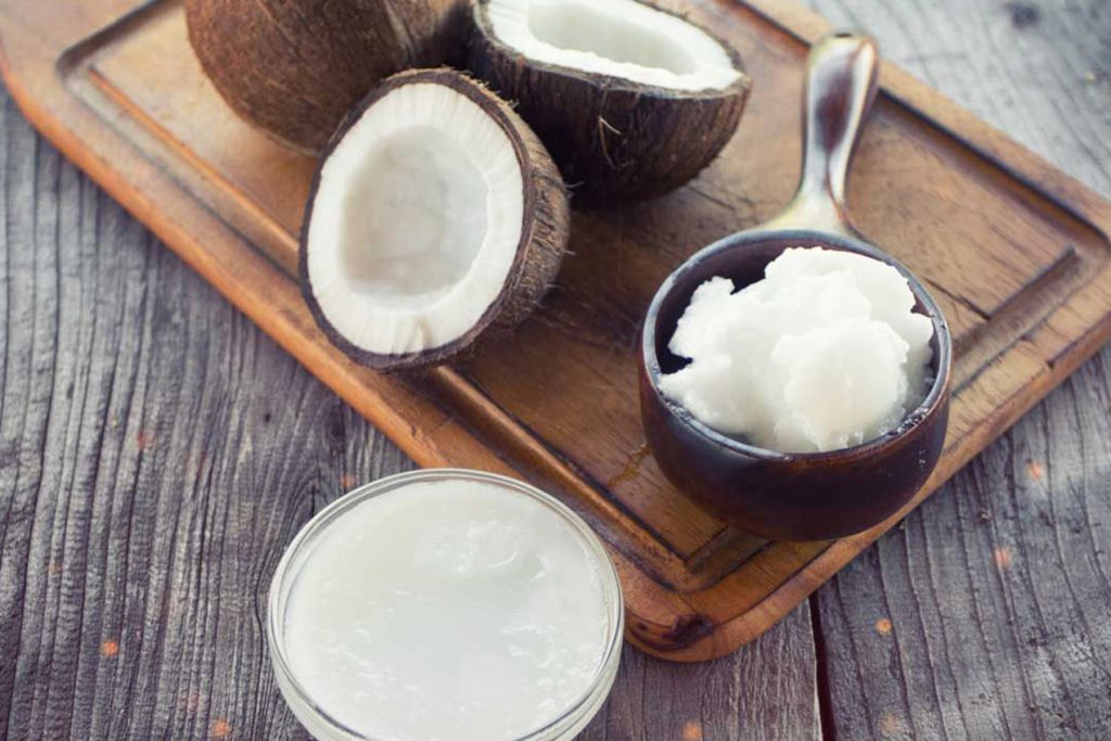 Coconut Oil & Coconuts on Wooden Cutting Board