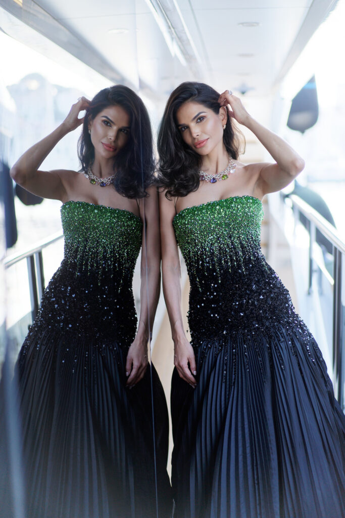 Fashion influencer Victoria Barbara style aboard boat before 2022 Cannes Film Festival Elvis premiere wearing black & green Tony Ward Couture dress & Bvlgari jewelry with makeup by Jonathan Sanchez