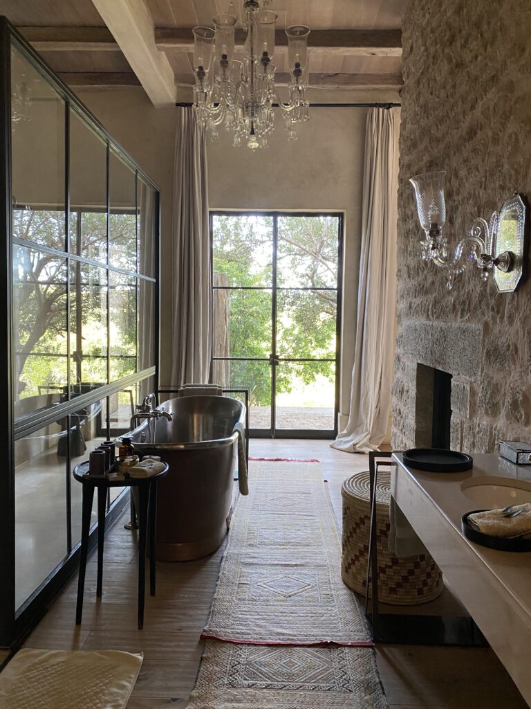 Luxury safari lodge bathroom interior Arijiju Kenya stone walls freestanding tub