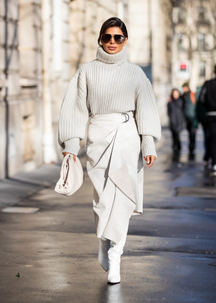 Victoria Barbara walking in Paris Fashion Week wearing an Isabel Marant knit sweater and leather skirt with Prada boots.