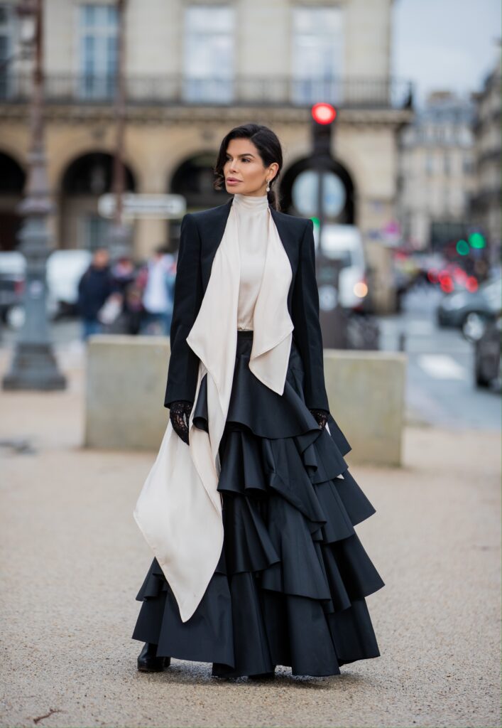 Victoria Barbara wearing dramatic black tiered skirt and tailored jacket on the way to Giambattista Valli during Paris Fashion Week