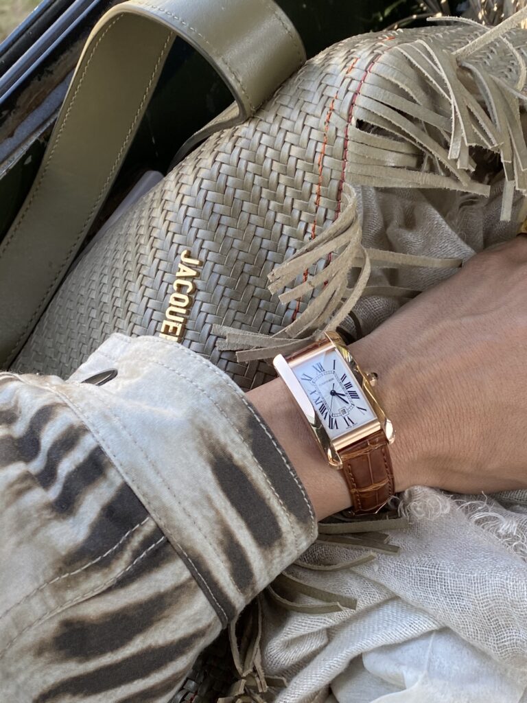 Luxury safari accessories watch and woven bag neutral tones travel style