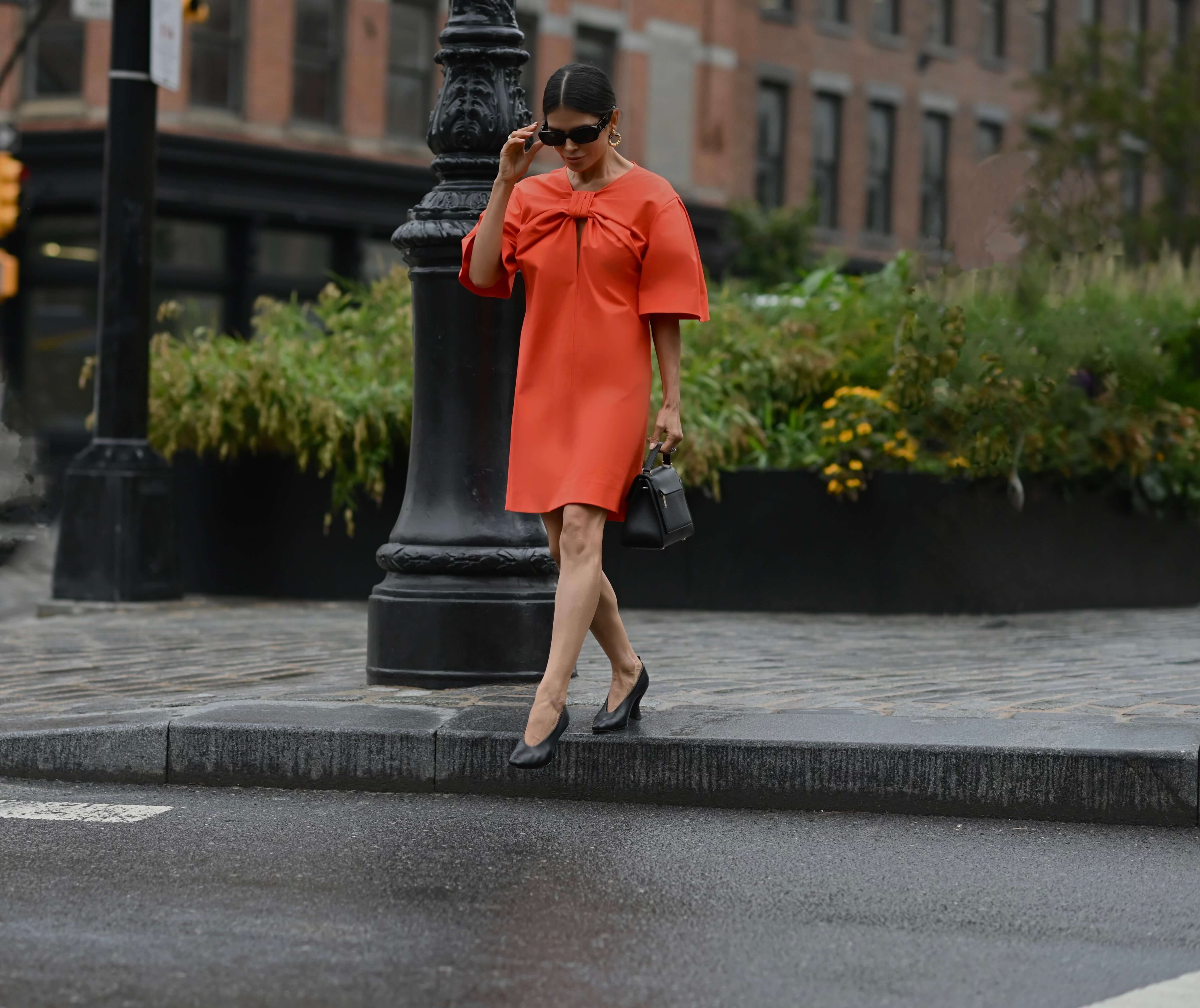 Victoria Barbara street style in red Carolina Herrera dress and Bottega Veneta shoes on her way to the Carolina Herrera Spring Summer 2022 Collection Runway Show during New York Fashion Week 2021