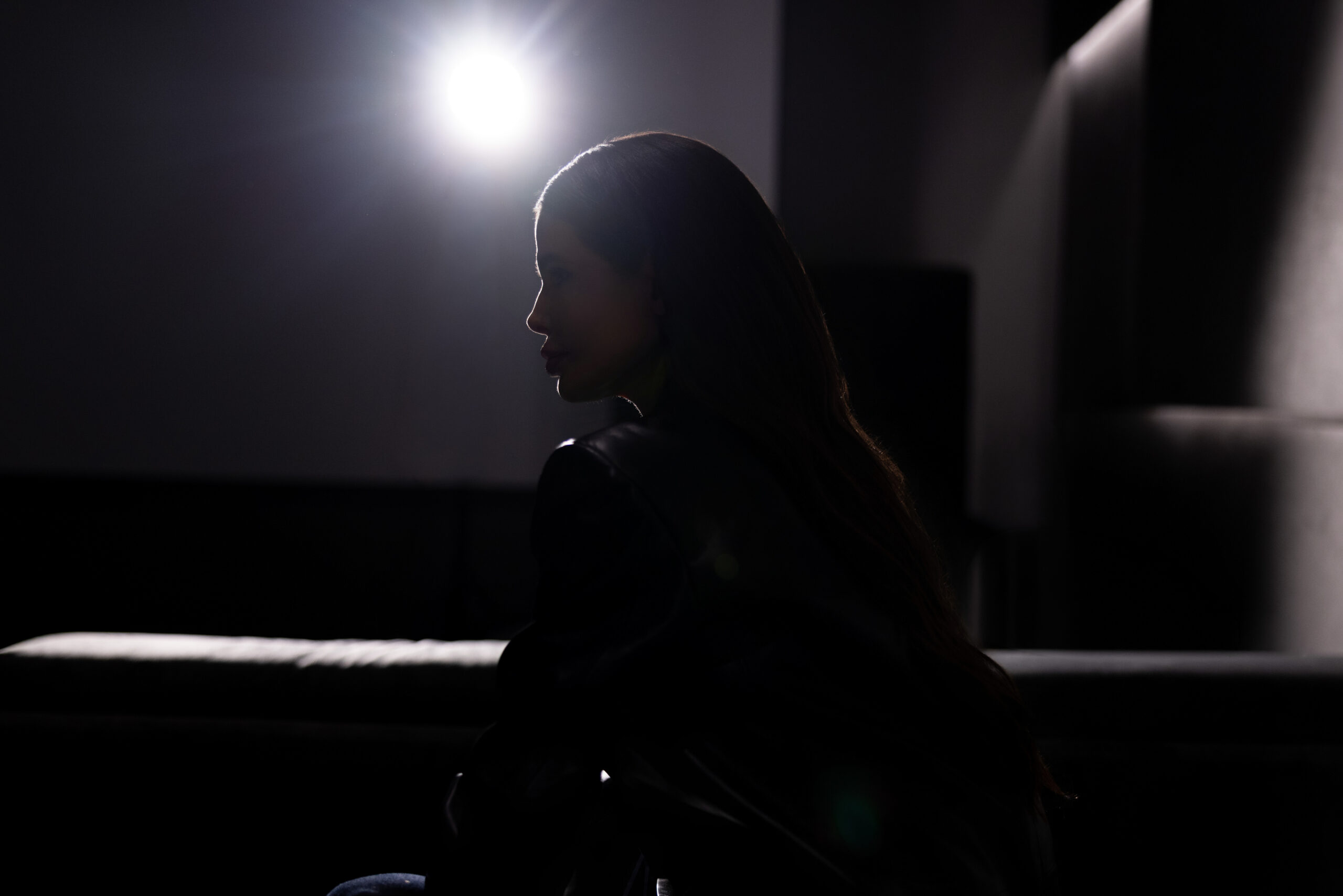 Victoria Barbara side profile in Khaite black leather look with dramatic shadow and backlighting