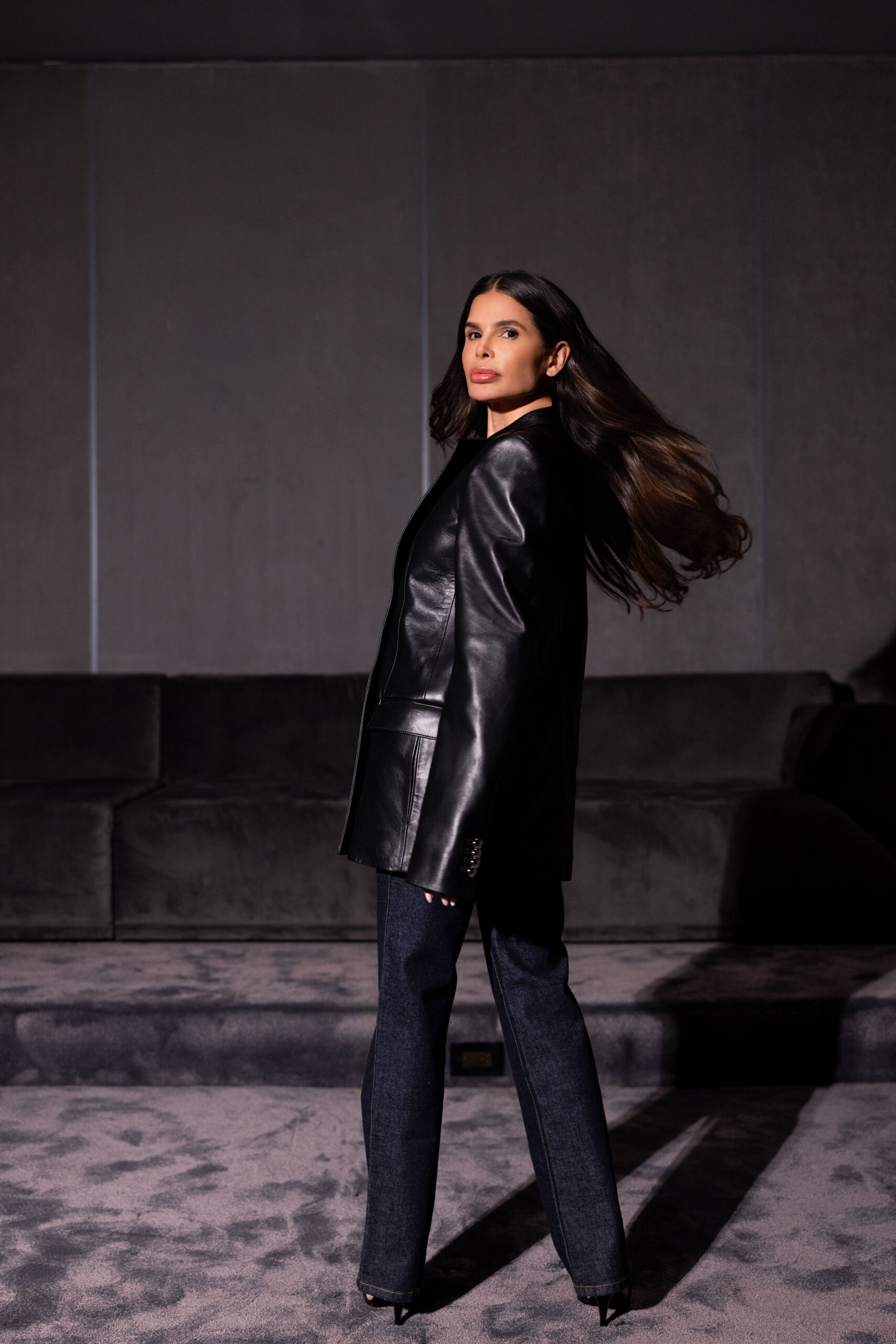 Victoria Barbara wearing Khaite black leather outfit with flowing hair in editorial studio setting