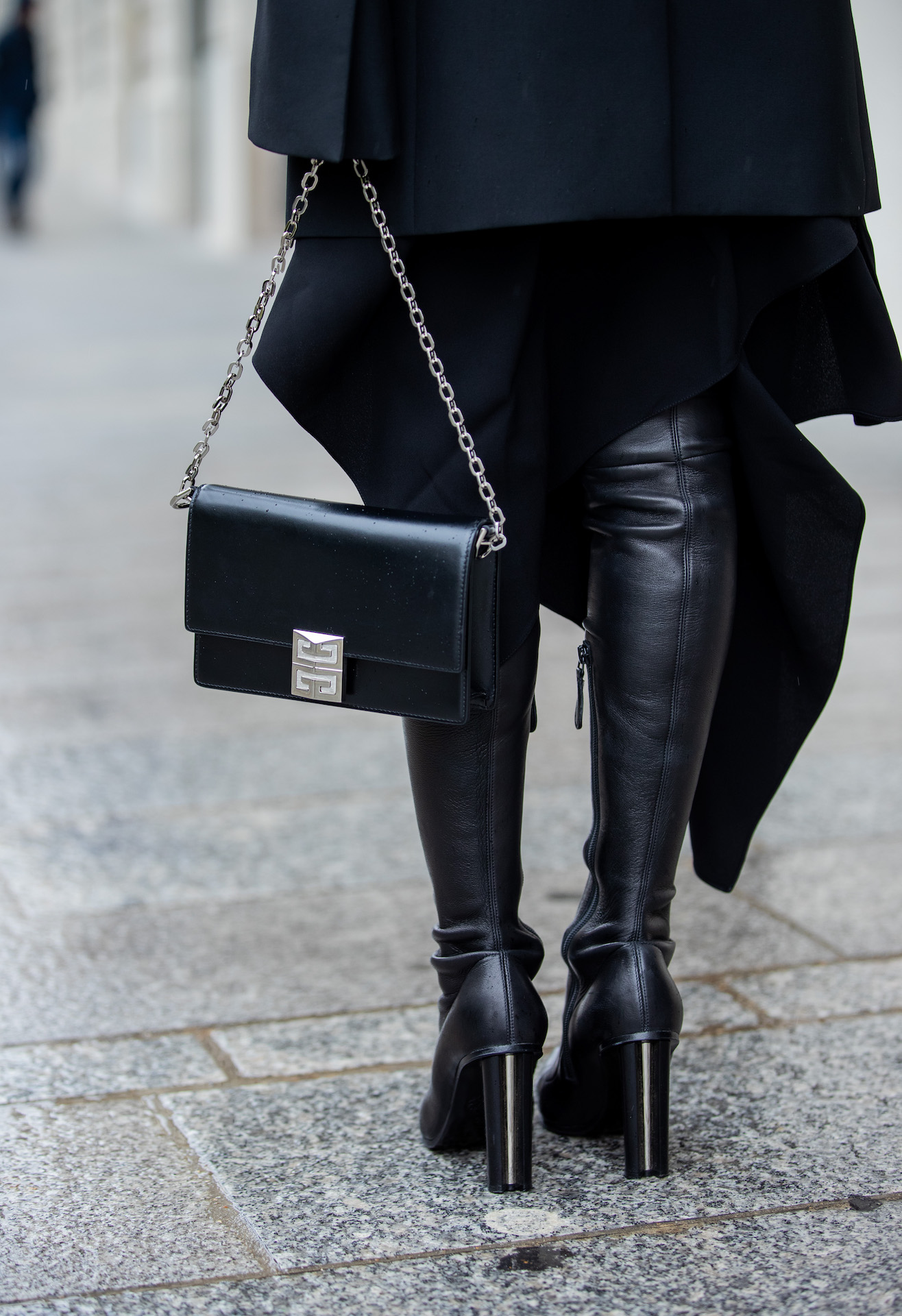 Close-up of Givenchy black chain bag, tailored trousers, and pointed heels on Paris street