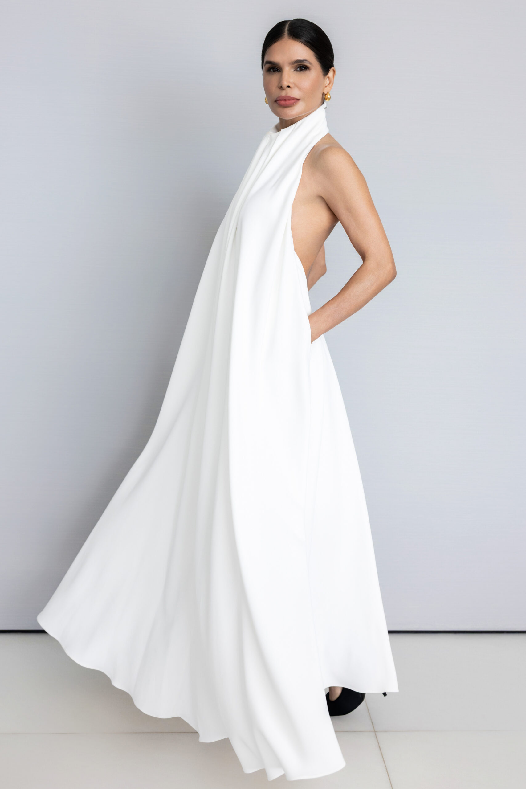 Victoria Barbara wearing a white Givenchy halter dress, styled with clean. minimal aesthetic against a neutral backdrop