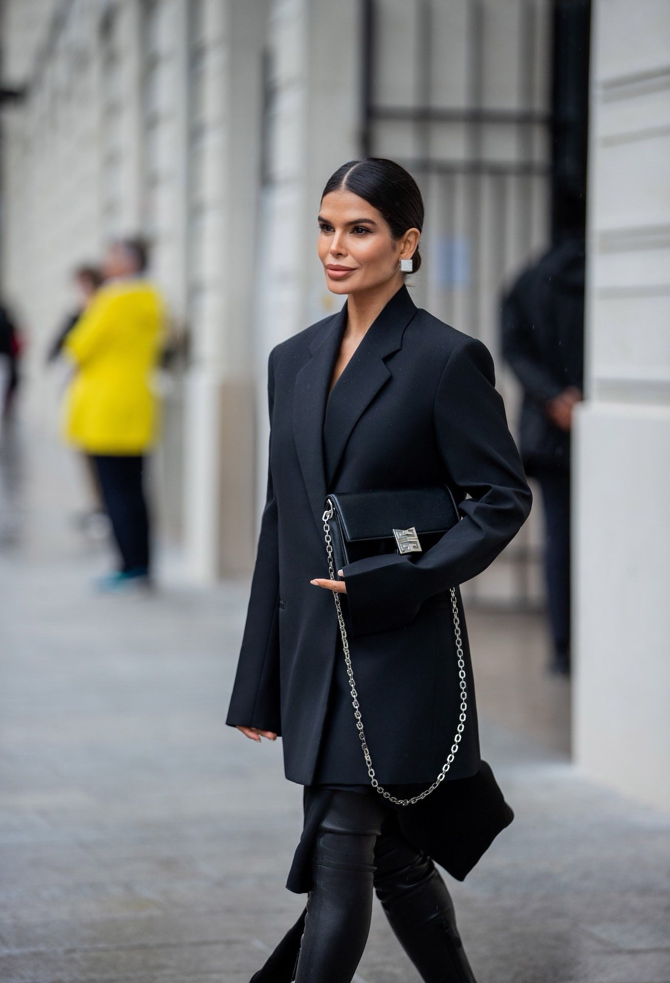 Victoria Barbara in side profile wearing Givenchy blazer and carrying a black chain bag in Paris street style