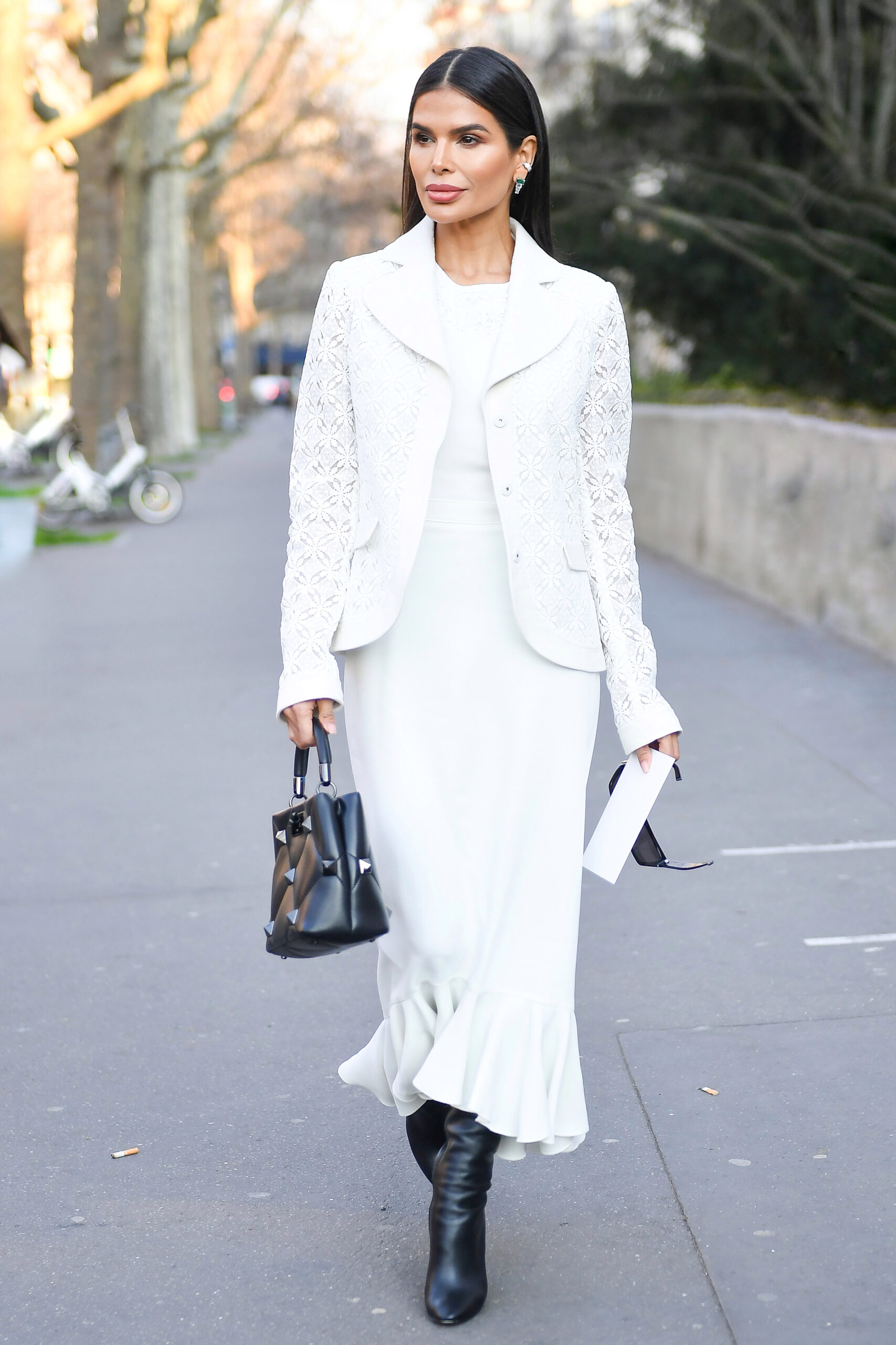 Victoria Barbara walking in Paris wearing a white Giambattista Valli dress with black leather boots and handbag during Paris Fashion Week