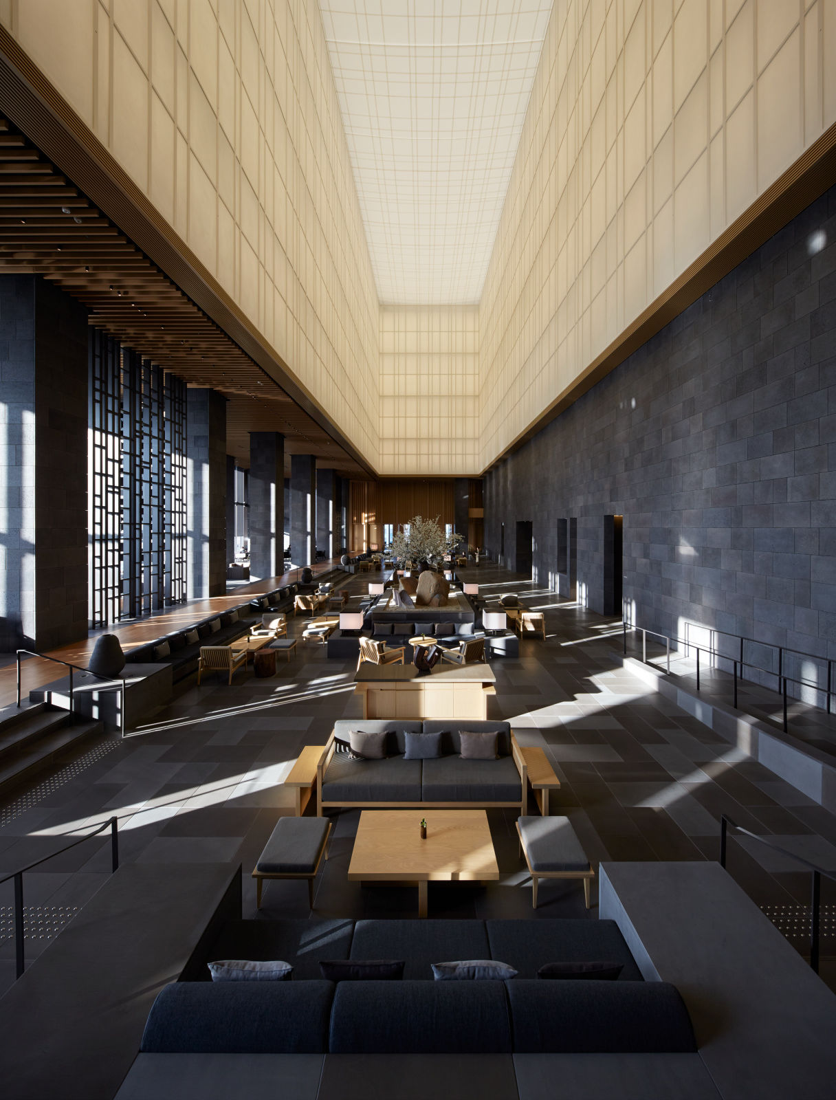 Aman Tokyo lobby with high ceiling, minimalist seating, and soft natural light inspired by traditional Japanese design