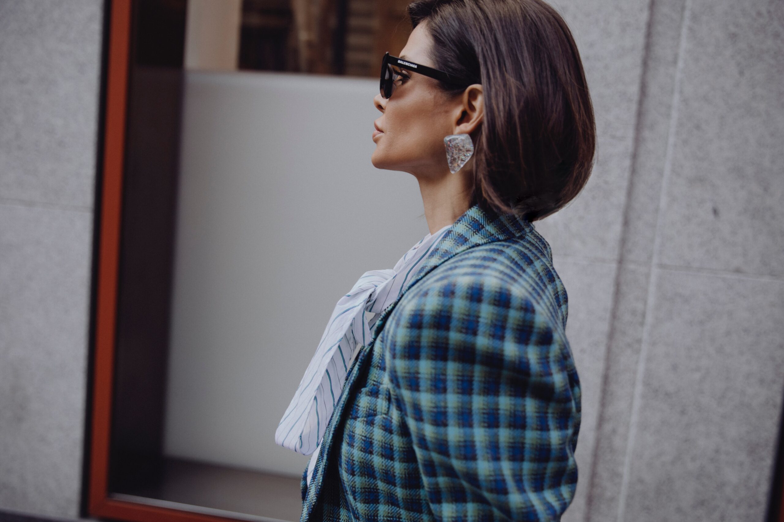 Close-up of Balenciaga styling with sunglasses and statement earring