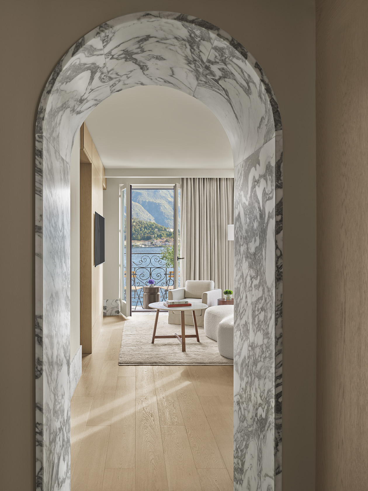 Marble arch framing suite interior with lake view at The Lake Como EDITION