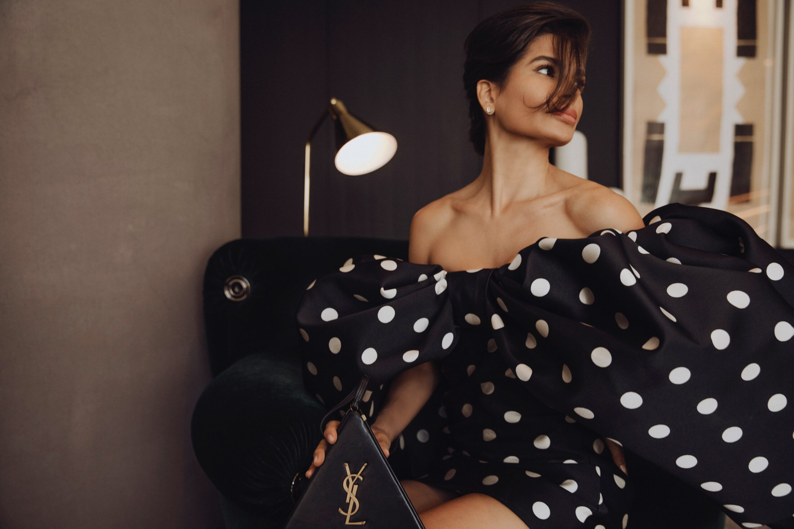 Givenchy polka dot dress with Saint Laurent bag styled in a seated editorial composition