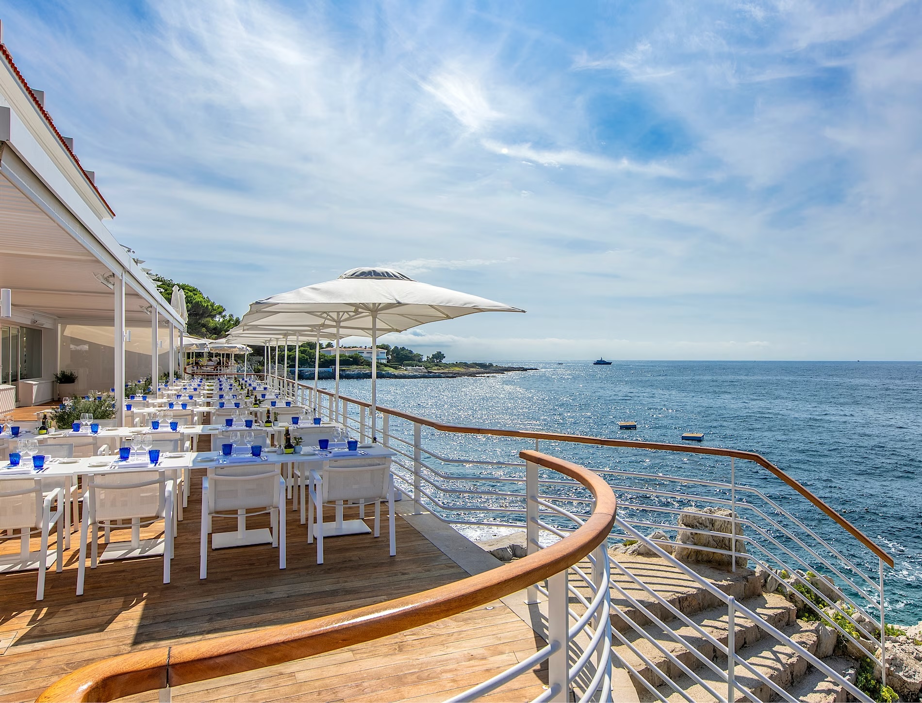 Hotel du Cap Eden Roc terrace dining with ocean view and white umbrellas in Cap d'Antibes