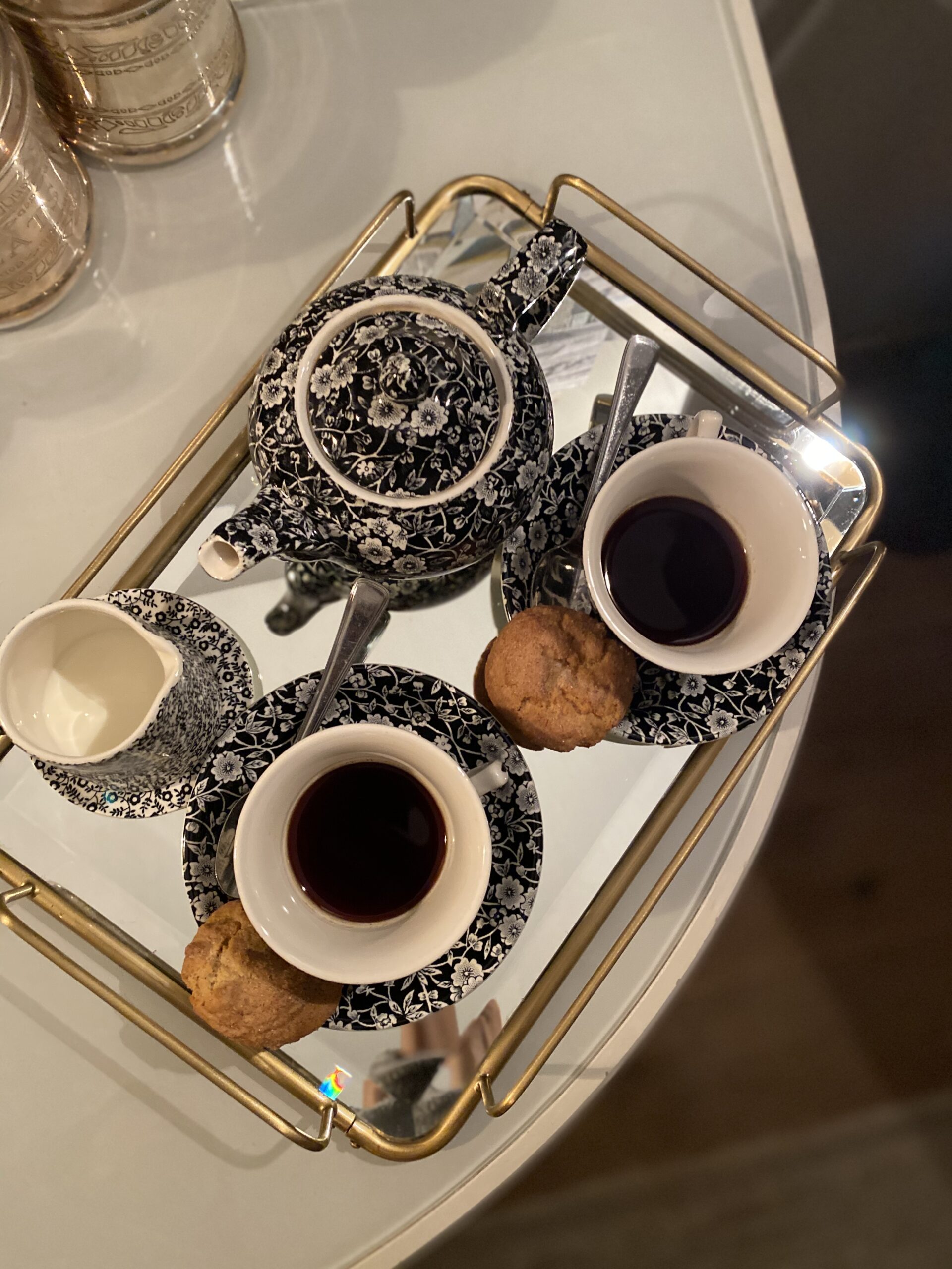 Tea service on mirrored tray with black and white porcelain cups at Soho House New York