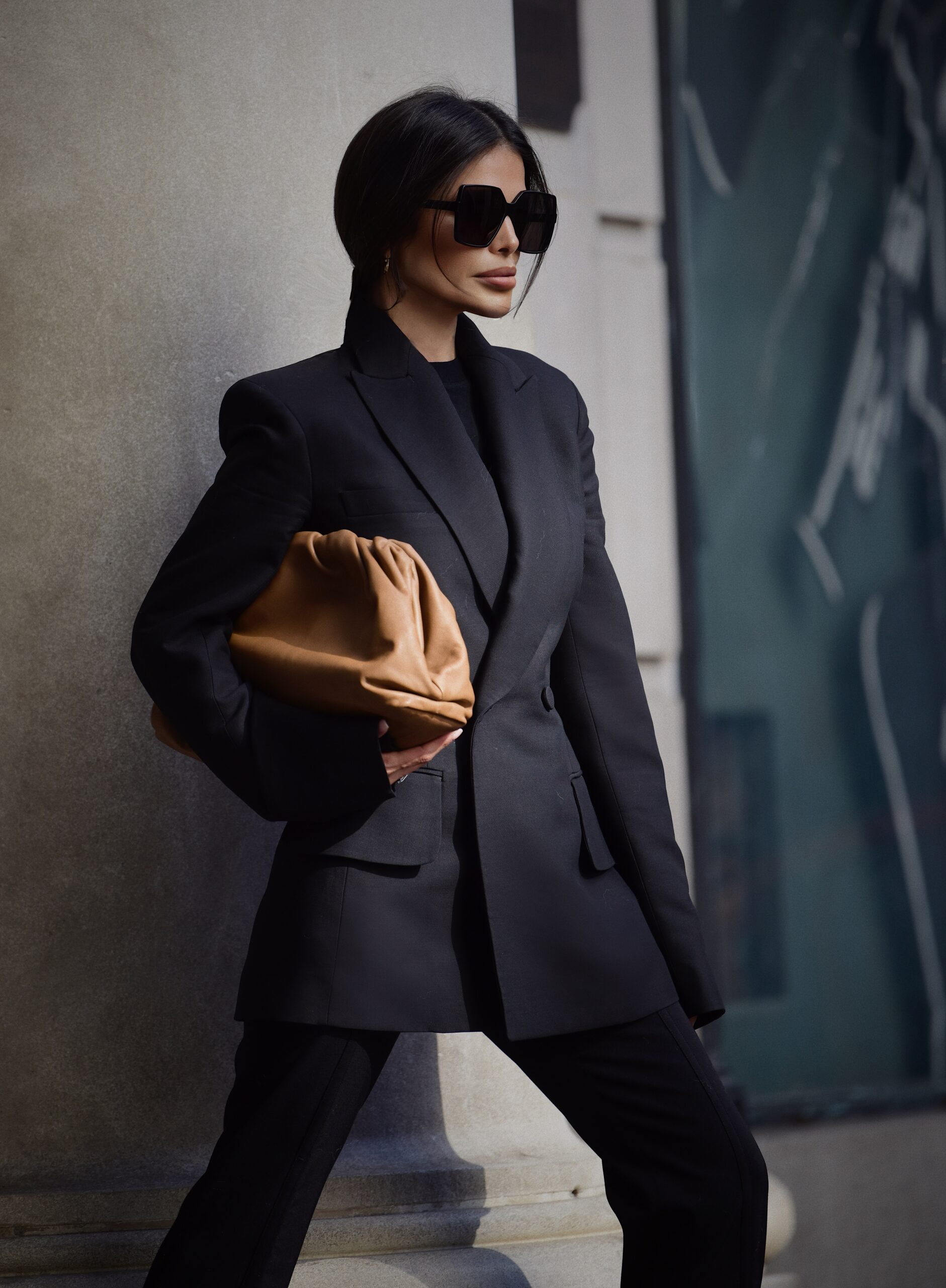 Detail of Bottega Veneta pouch with Khaite suit and Max Mara coat styling