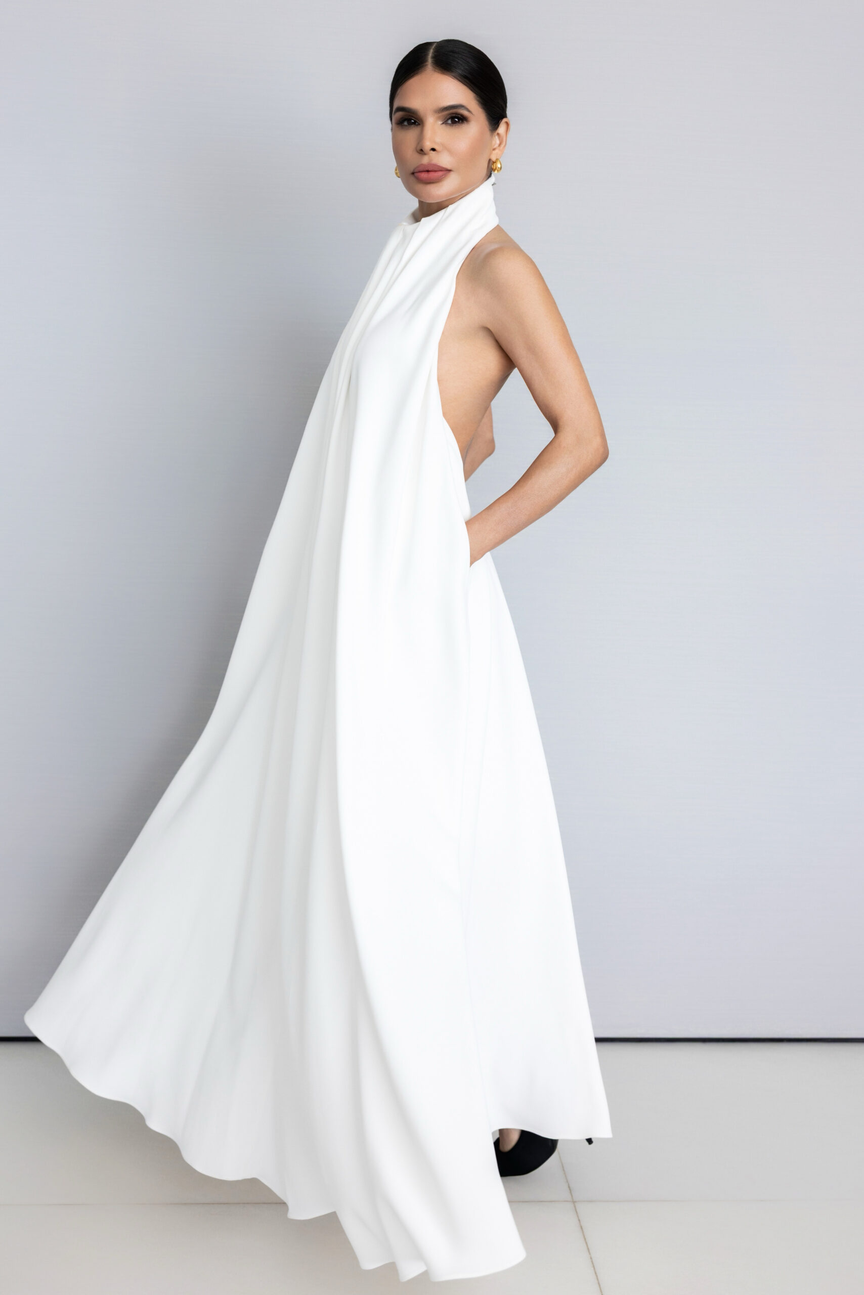 Victoria Barbara wearing a white Givenchy halter dress, styled with clean. minimal aesthetic against a neutral backdrop
