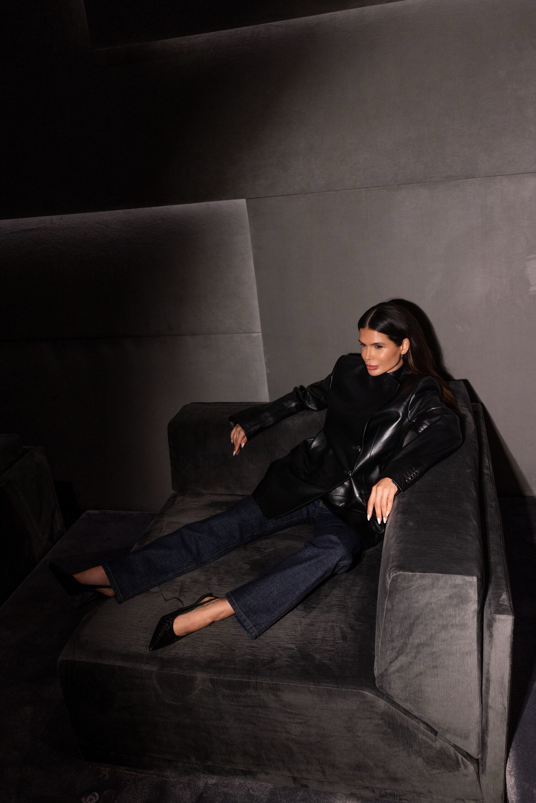 Victoria Barbara wearing Khaite black look seated in minimalist studio setting with dramatic lighting