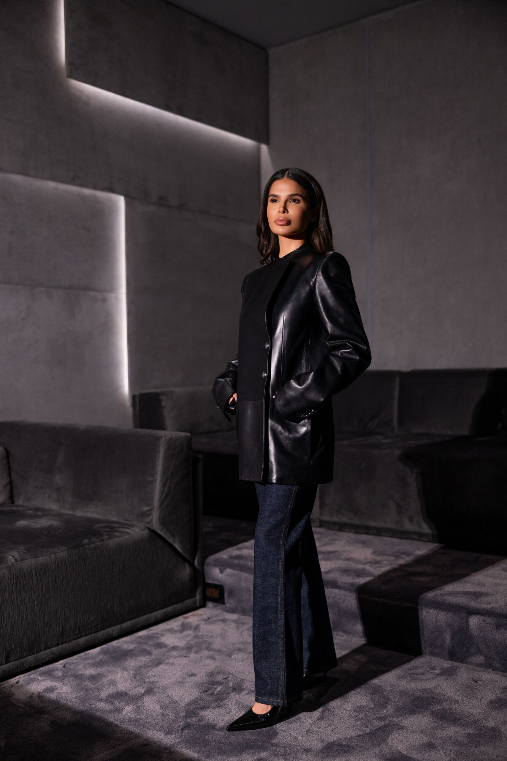 Khaite black leather blazer and dark denim styled in a full-length editorial look with minimal, structured silhouette