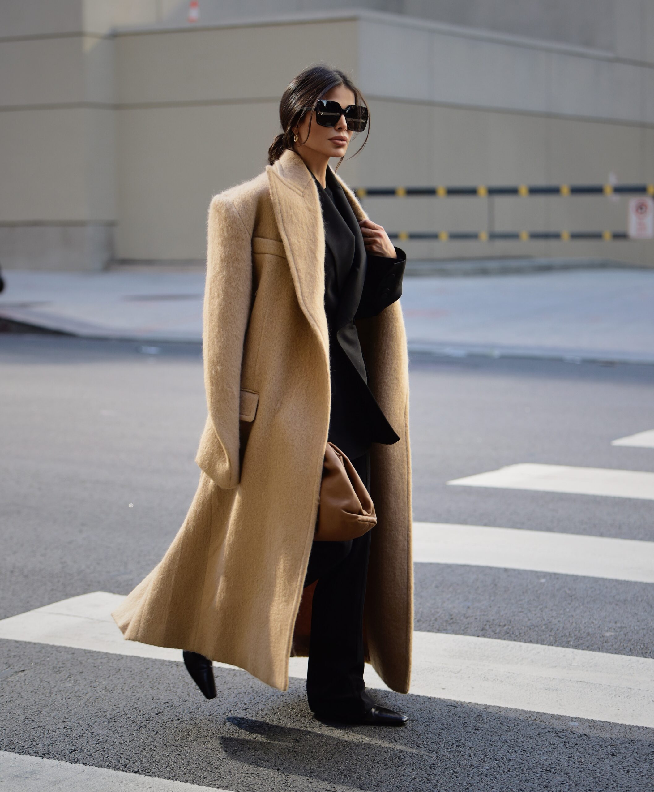 Victoria Barbara in black Khaite tailored suit styled with Max Mara coat and Bottega Veneta bag in New York
