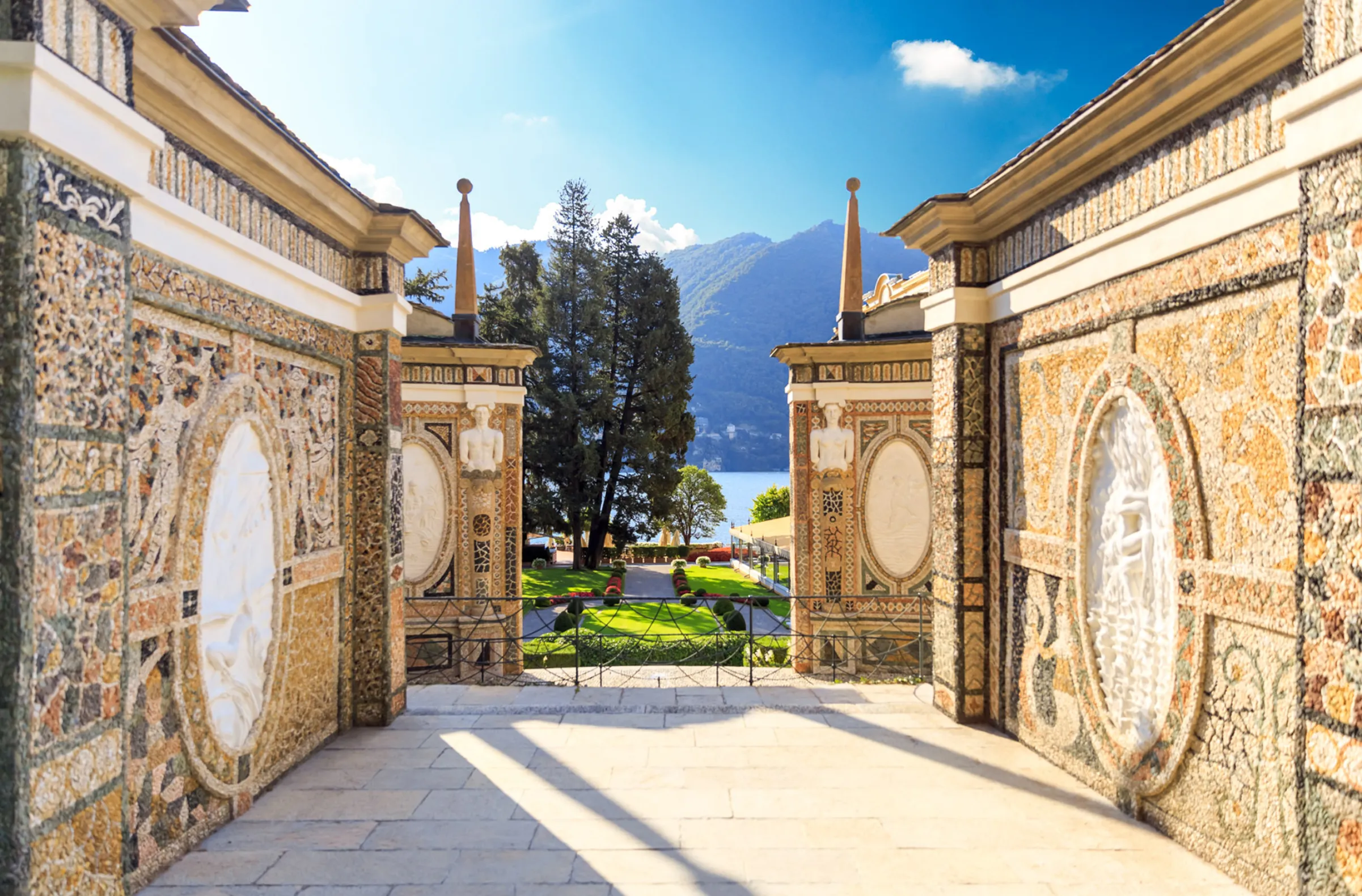 Villa d’Este entrance courtyard in Lake Como featuring symmetrical architecture, stone façade, and manicured garden surroundings