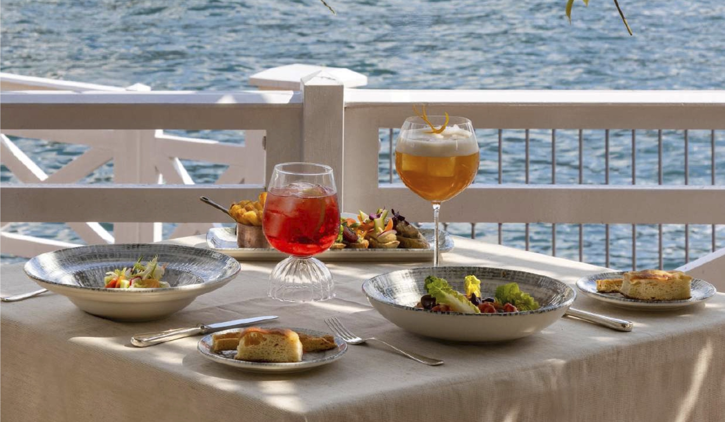 Table setting with lake view at Villa d'Este Lake Como with drinks and plated dishes