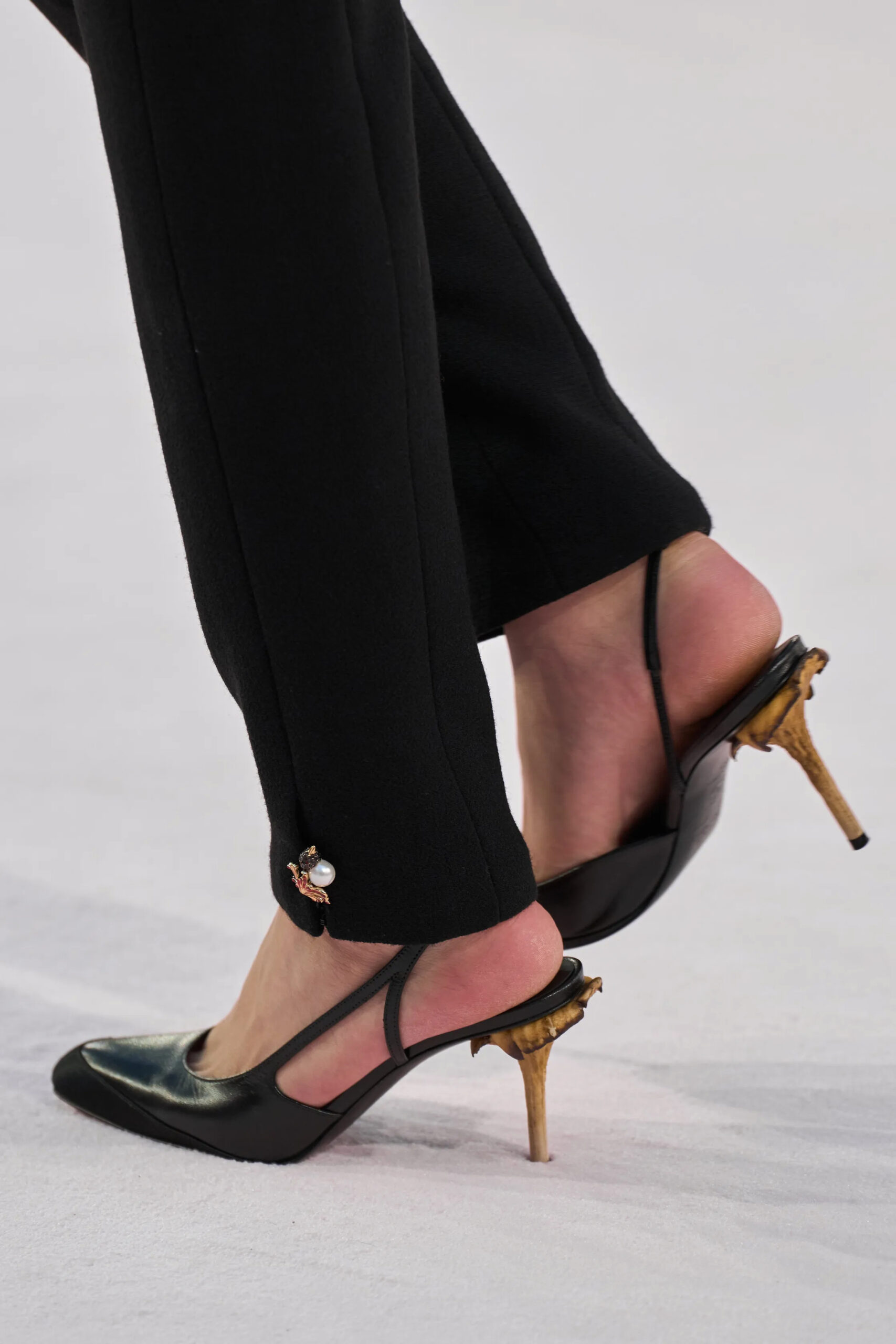 Close-up of black Chanel slingback heels with sculptural gold heel detail during Chanel Spring 2026 Couture