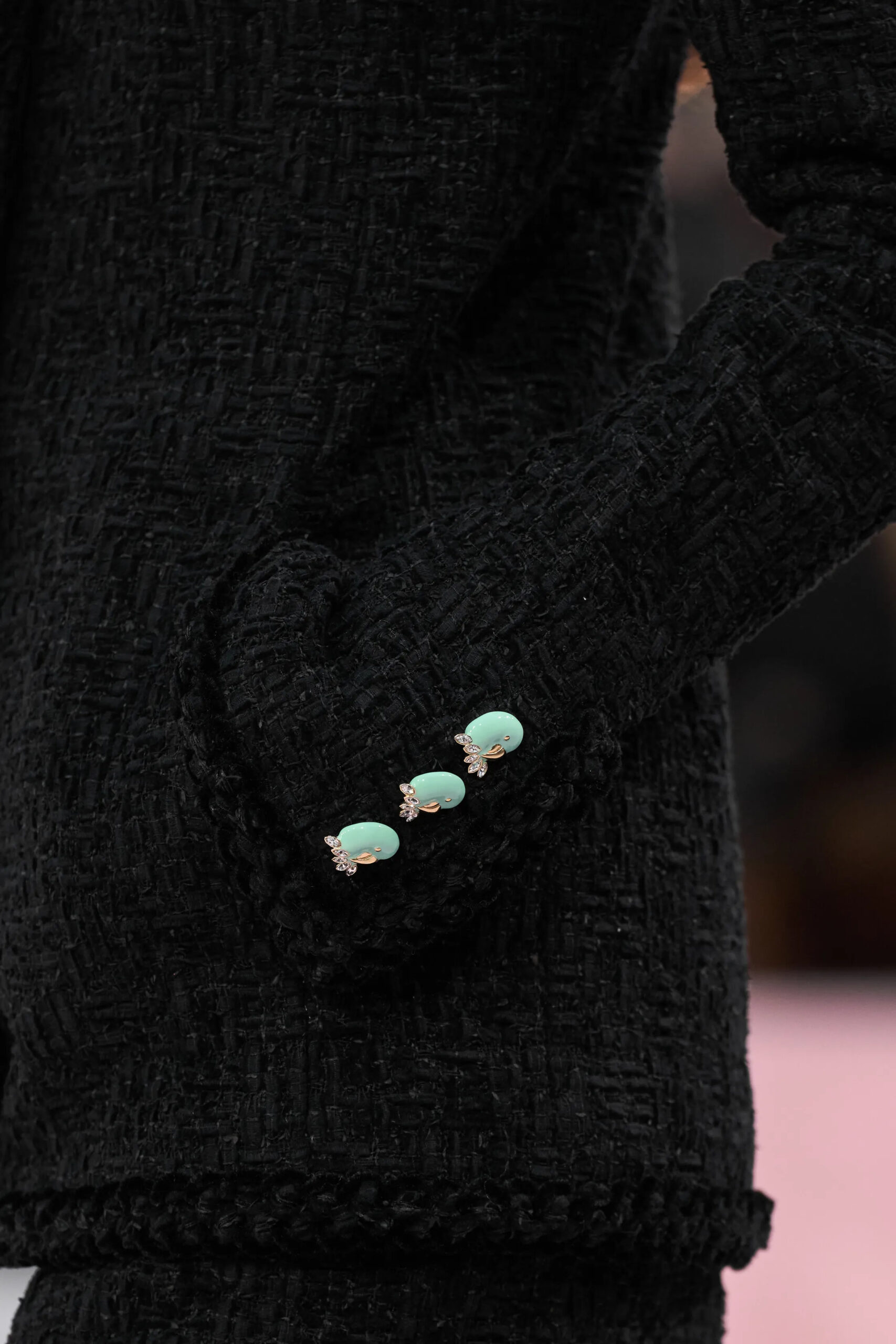 Close-up of black Chanel tweed sleeve with turquoise jeweled buttons during Spring 2026 Couture