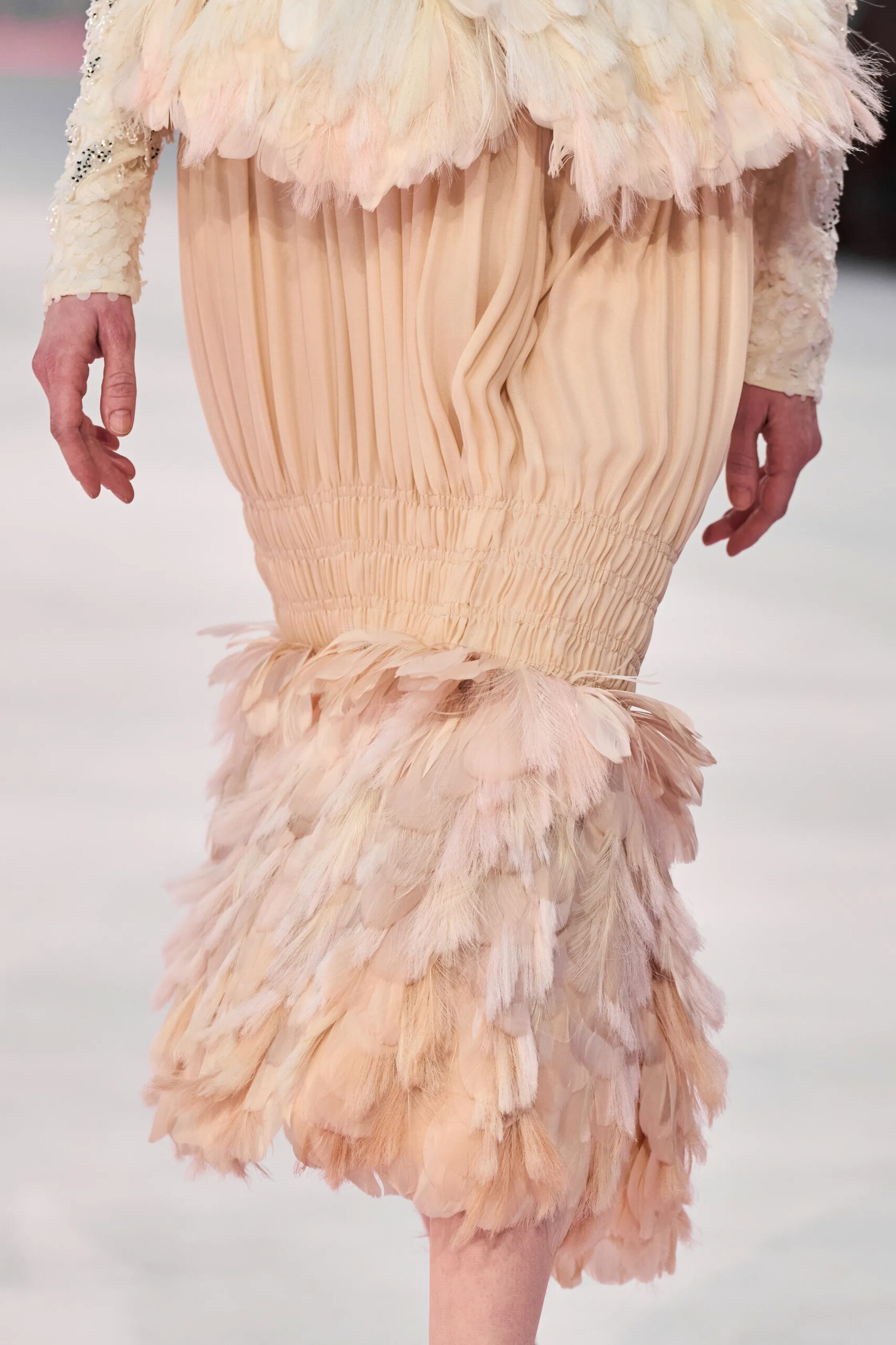 Close-up of blush feather and gathered chiffon detailing on a Chanel couture dress