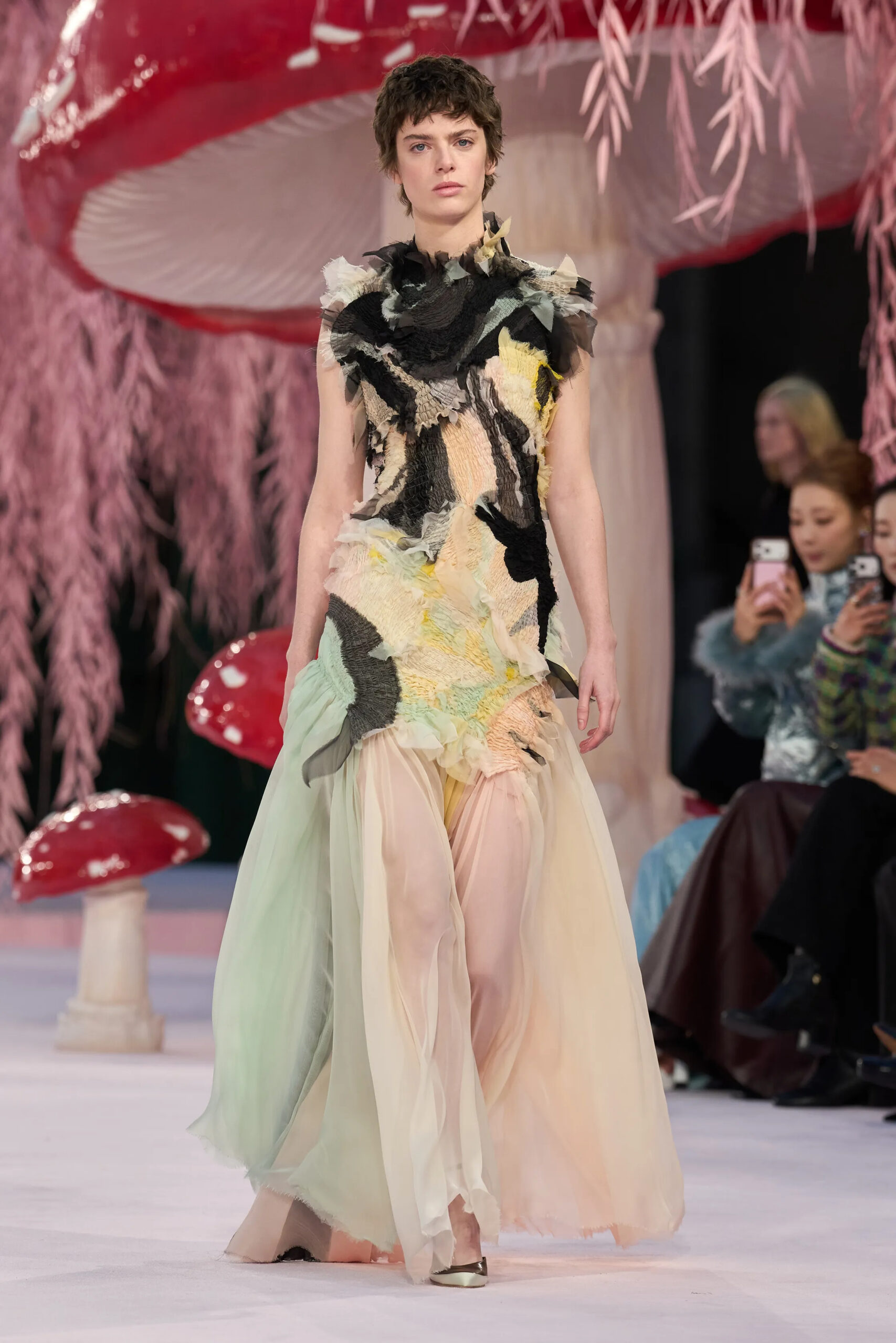 Model wearing an abstract layered Chanel couture dress with black, cream, yellow, and soft pastel textile construction on the Spring 2026 Couture runway