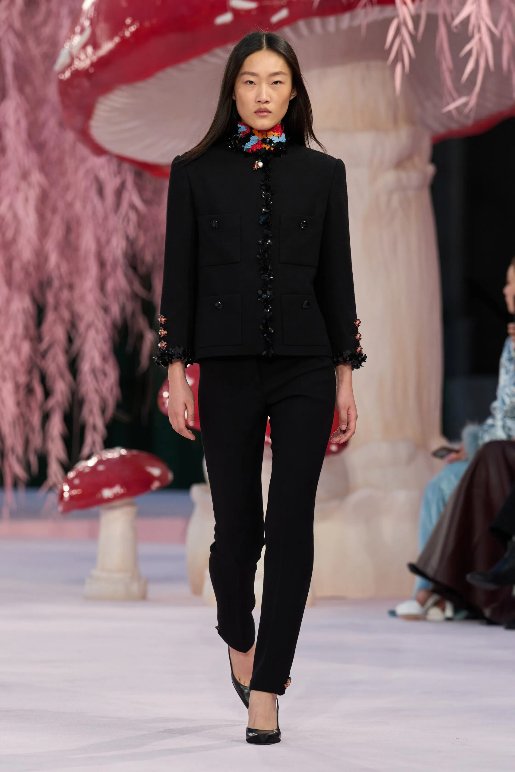 Model in structured black Chanel tailoring with colorful embellished neckline details during Chanel Spring 2026 Couture