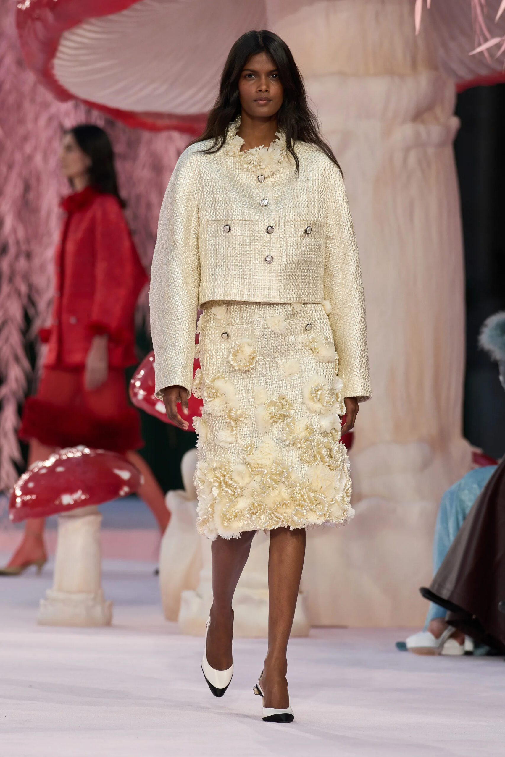 Model in ivory Chanel tweed jacket and embellished floral skirt during Chanel Spring 2026 Couture