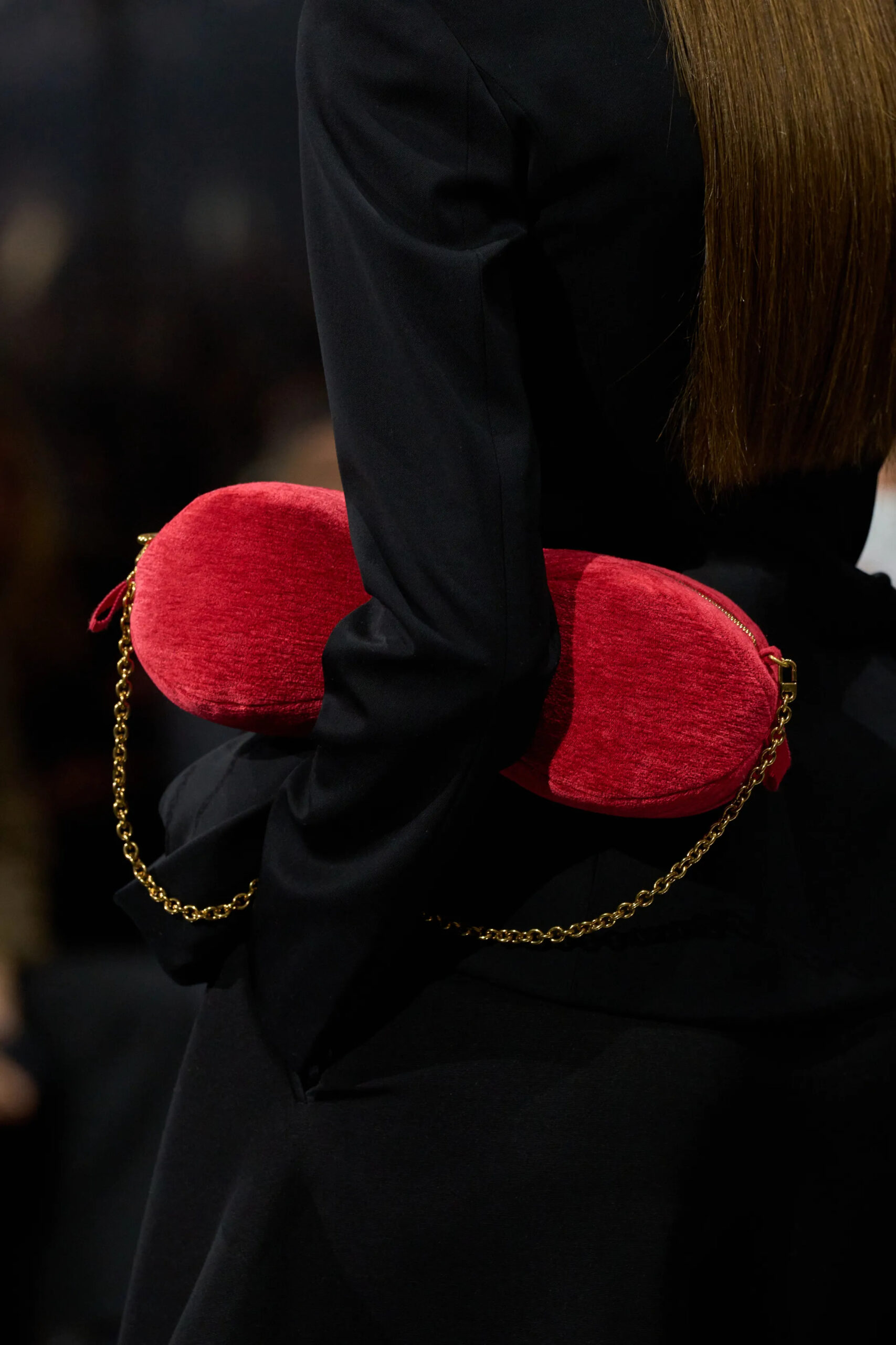 Close-up of red velvet Dior couture clutch with gold chain detail