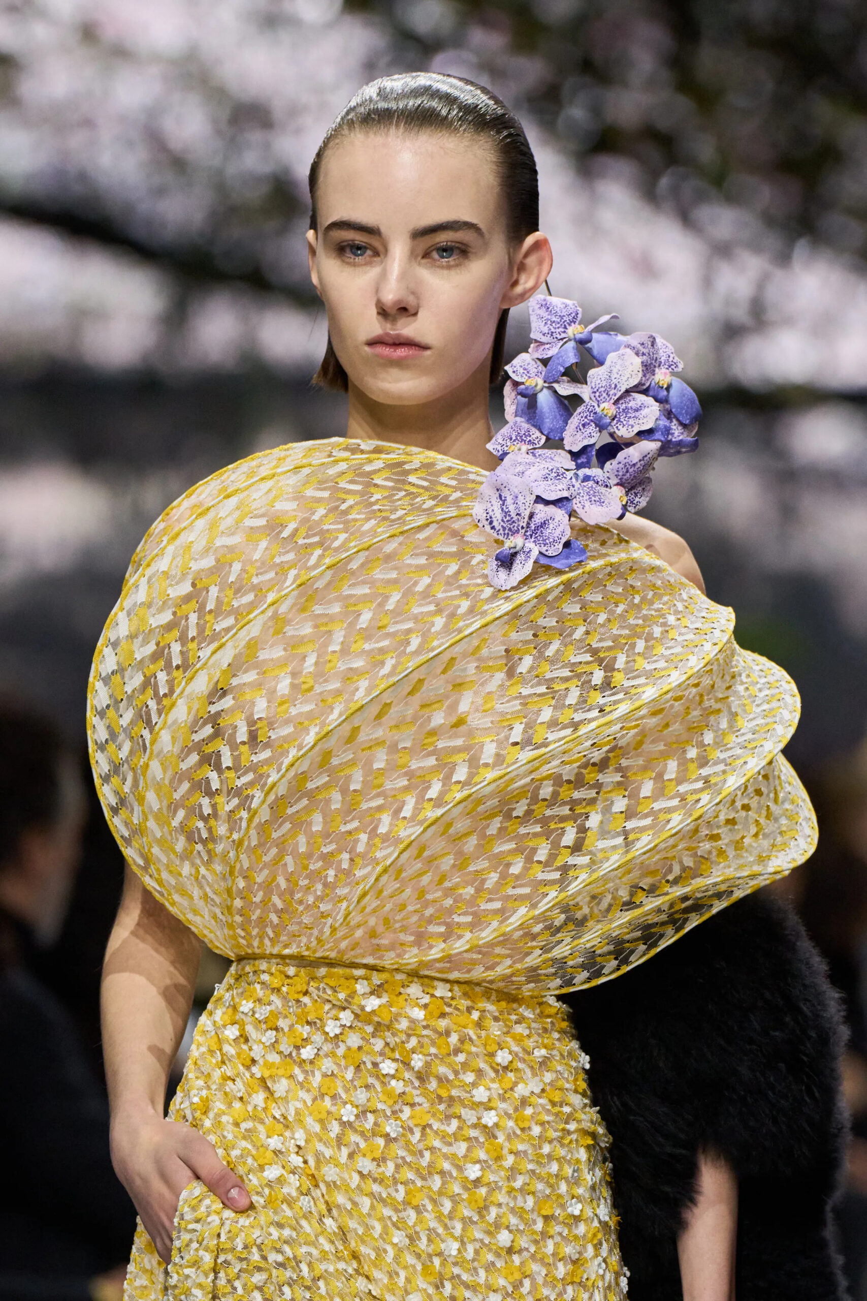 Close-up of yellow Dior couture sculptural dress with lavender floral shoulder detail