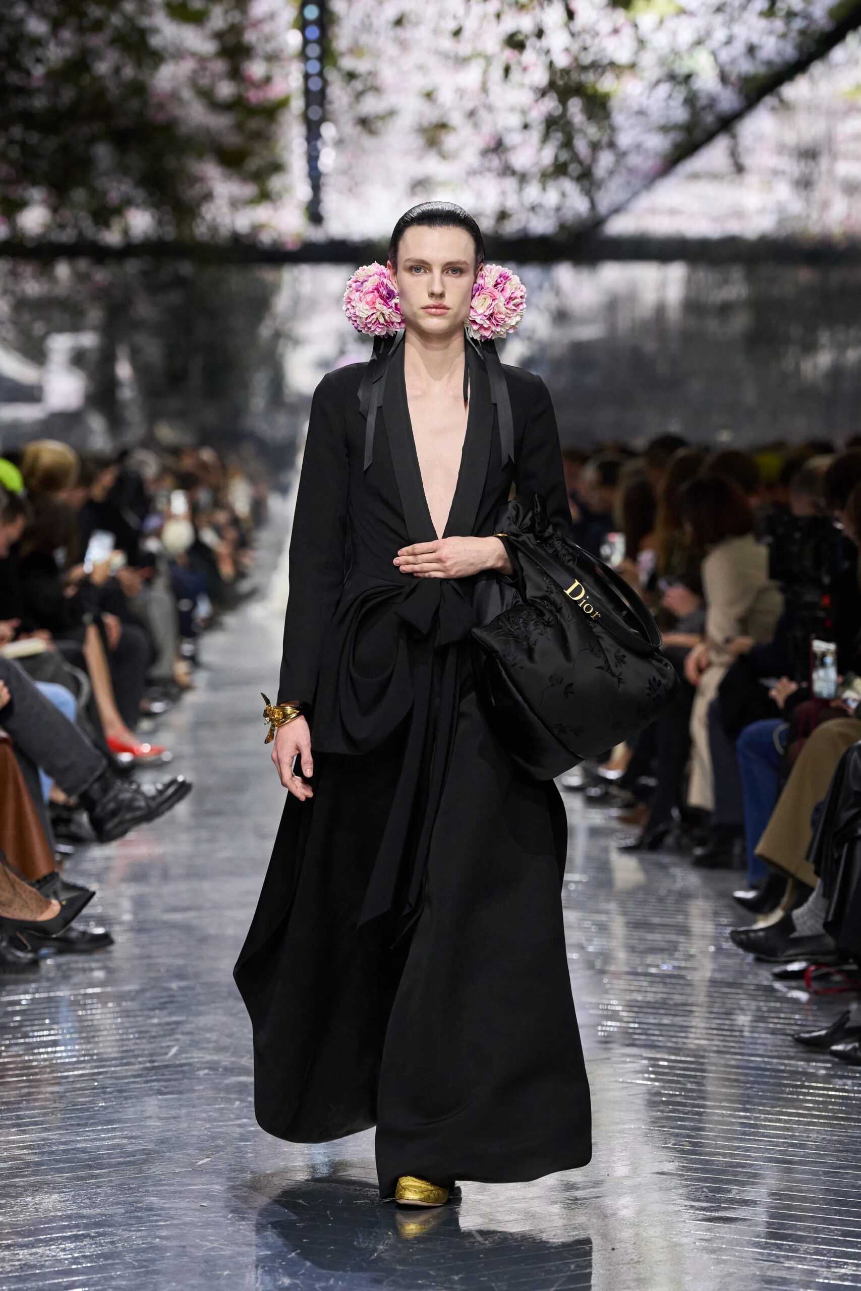 Model wearing black Dior couture tailored dress with floral embellishments and draped silhouette