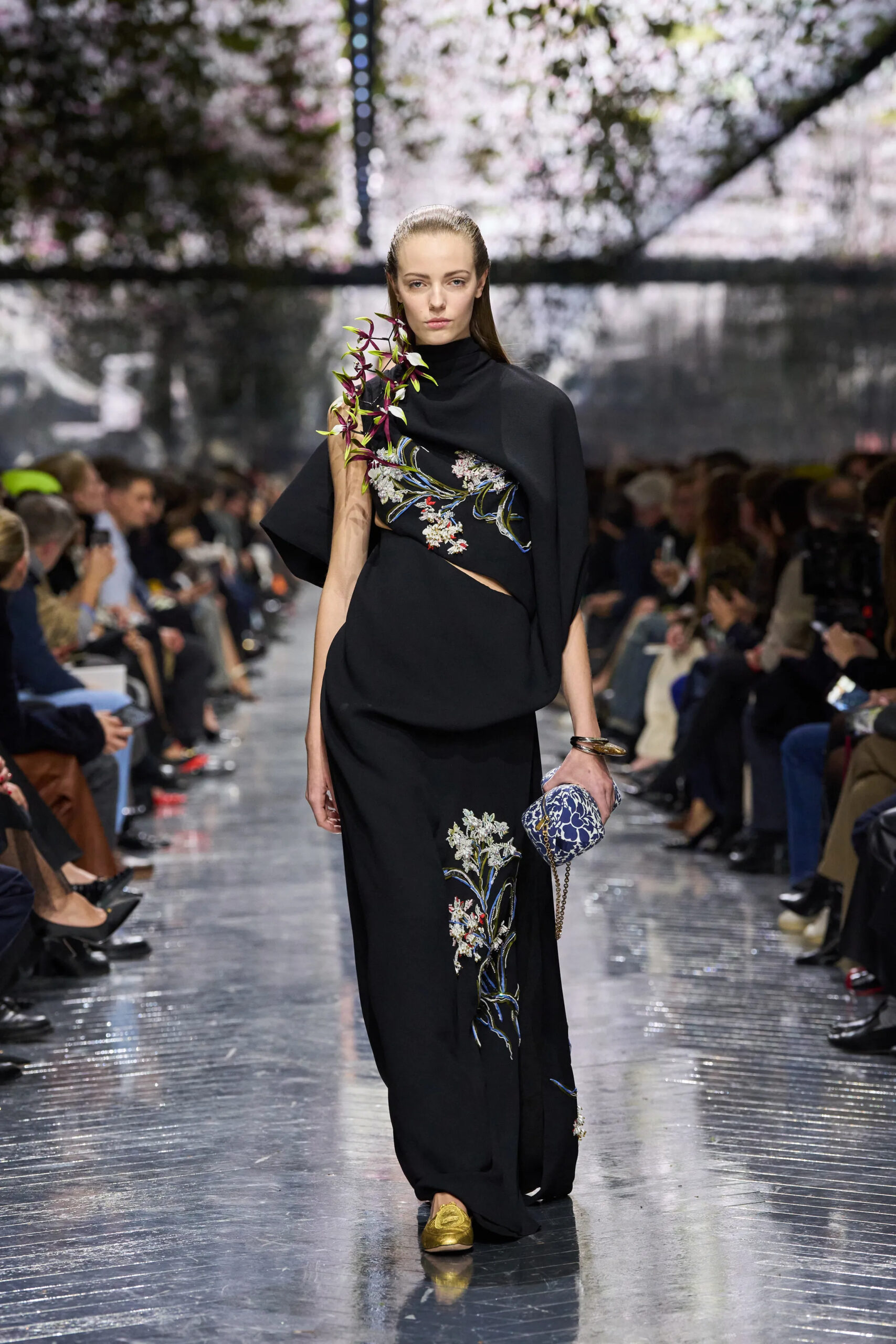Model in black Christian Dior Spring 2026 Couture gown with floral embroidery and sculptural shoulder drape