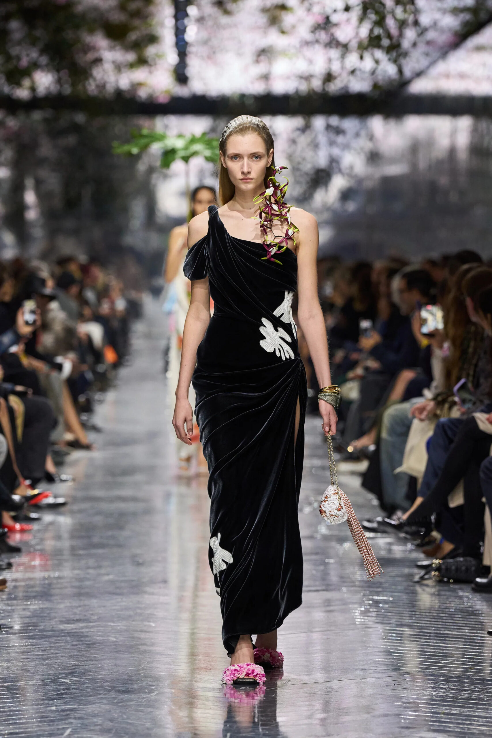 Model in black velvet Dior couture gown with draped silhouette and embellished accessories