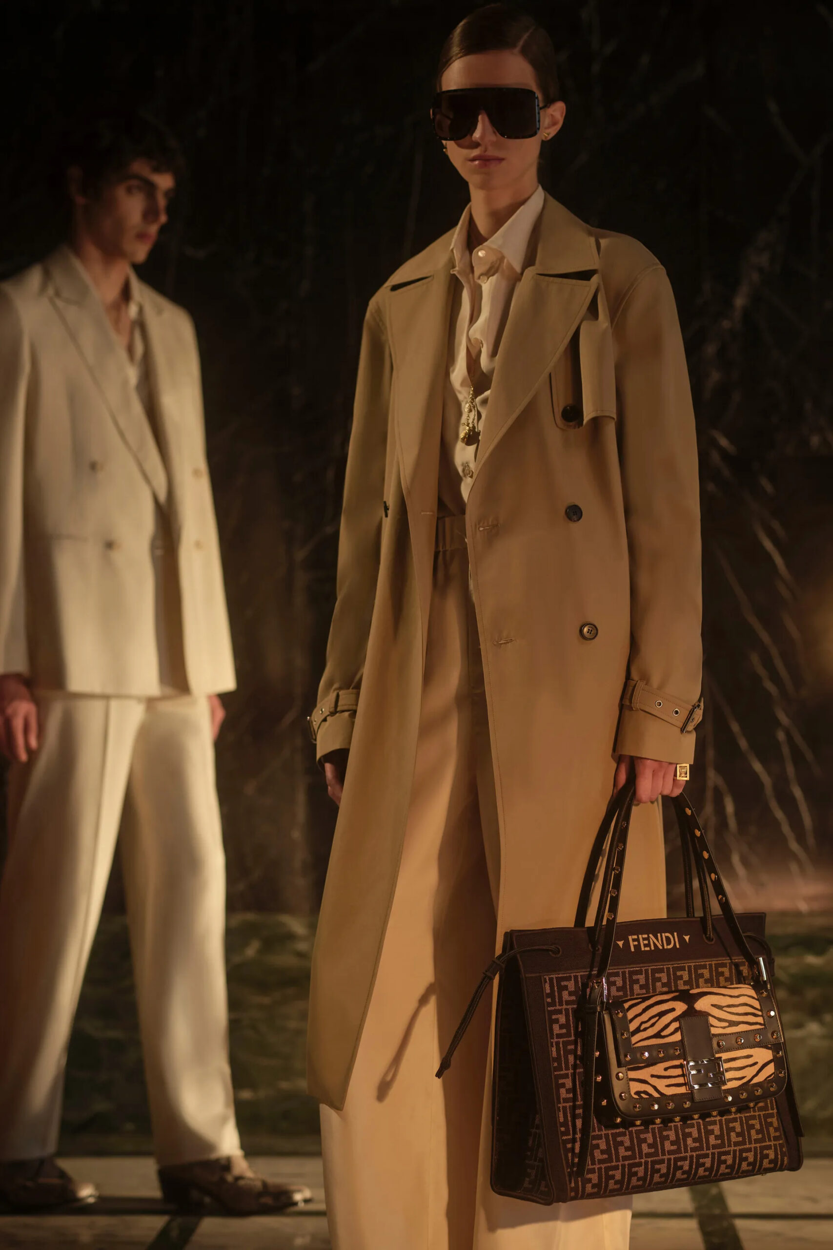 Camel trench coat styled with oversized sunglasses and monogram Fendi tote bag from Resort 2027