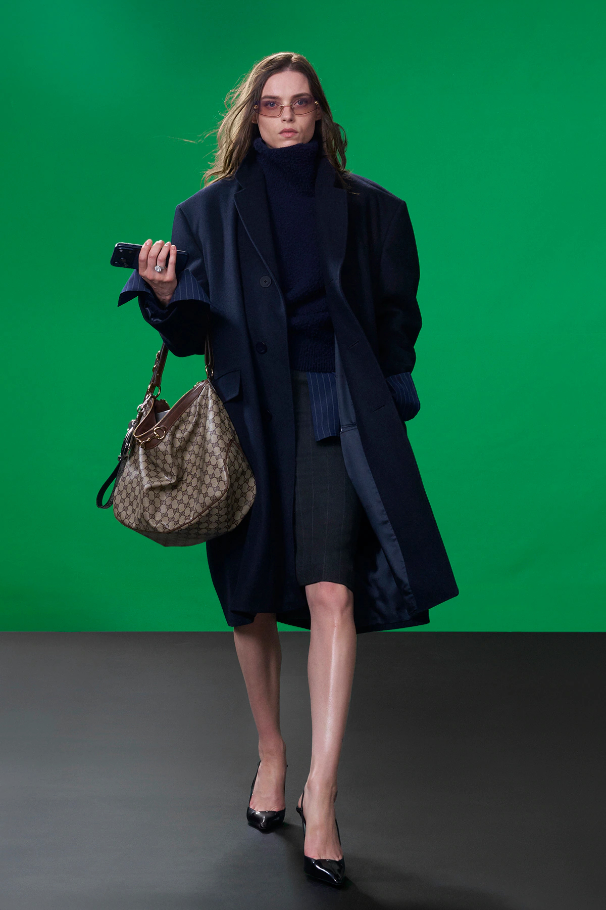 Model wearing oversized navy Gucci coat with structured tailoring and slingback heels during Gucci Resort 2027