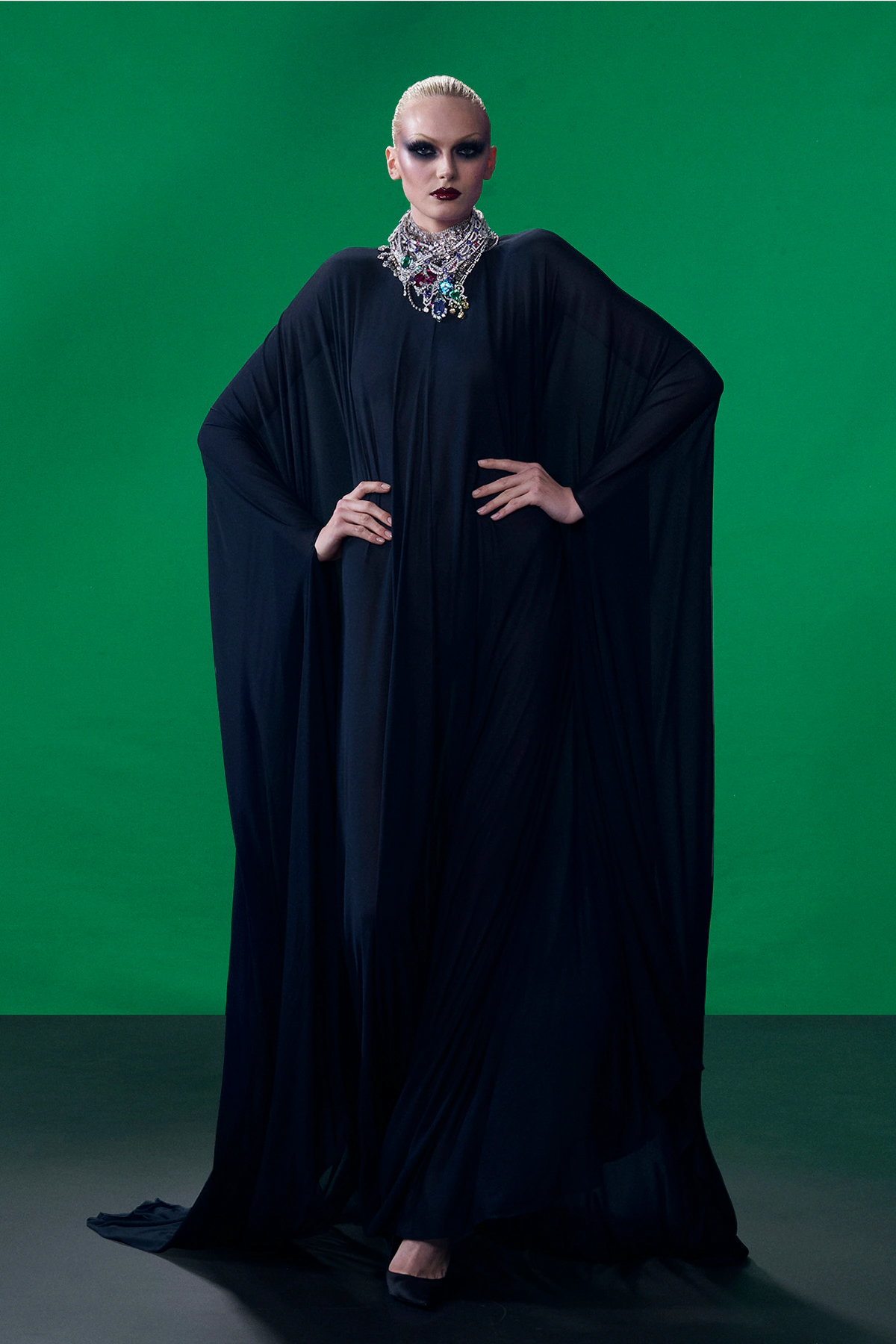 Model wearing black draped Gucci caftan with oversized jeweled necklace during Gucci Resort 2027