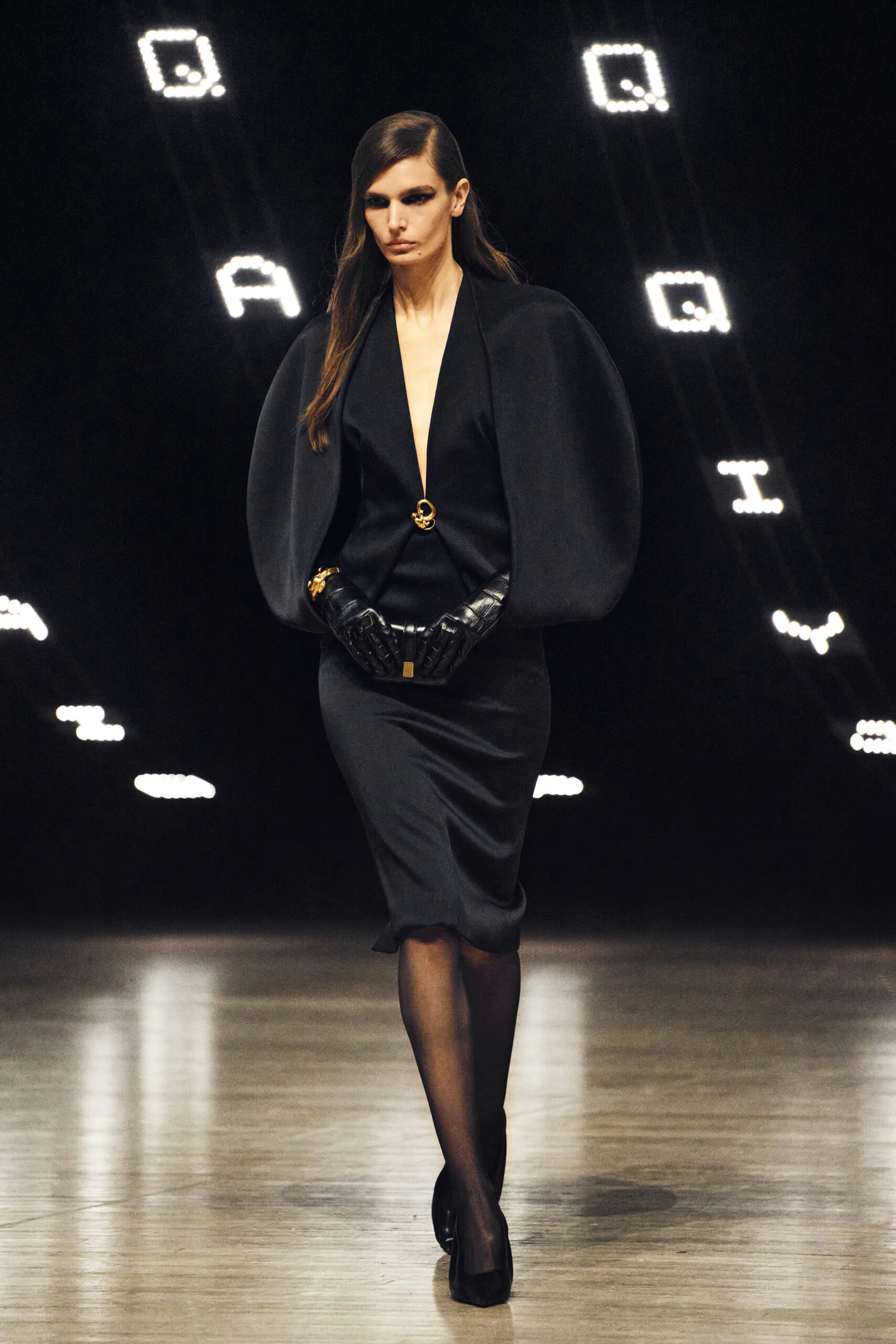 Model wearing a fitted black dress with exaggerated sculptural sleeves at Khaite Fall Winter 2026 runway show