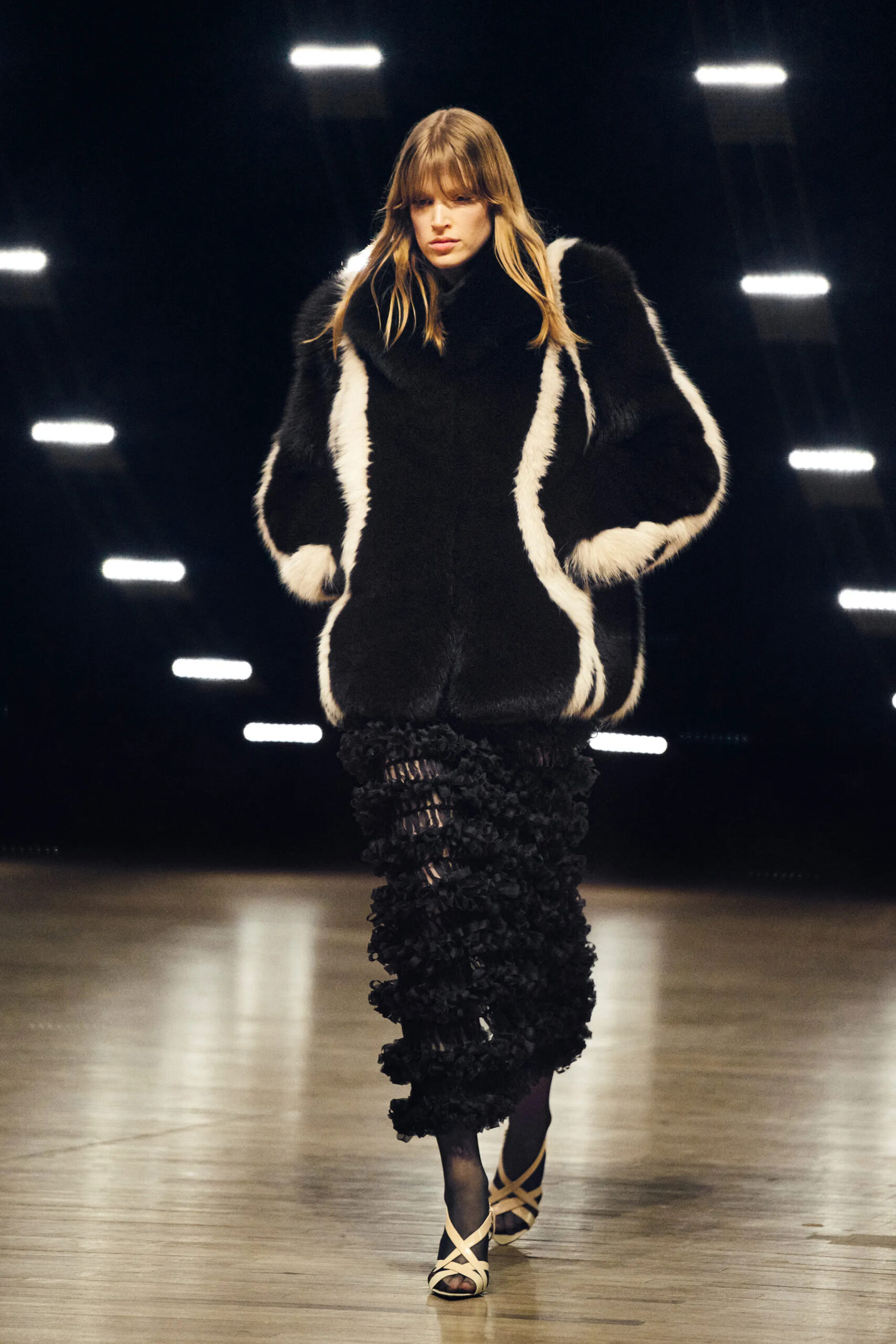 Model wearing a cropped black architectural jacket with a cream satin skirt at Khaite Fall Winter 2026 runway show