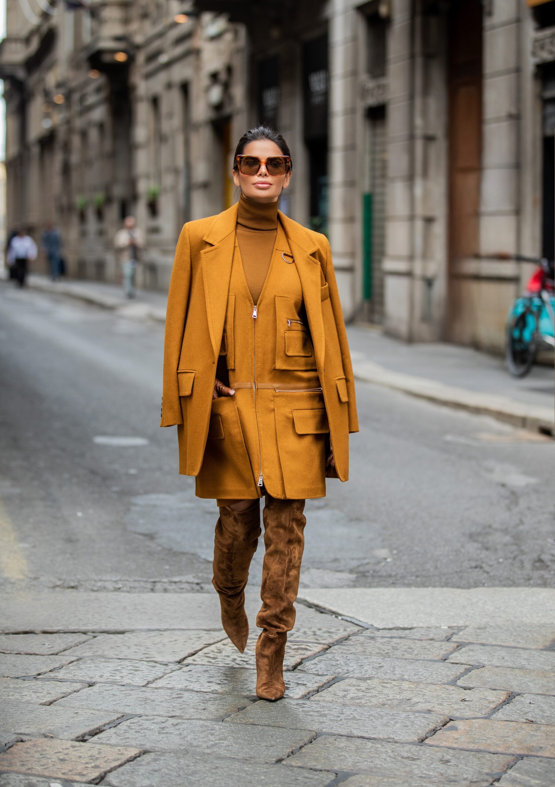 Victoria Barbara crossing a Milan street in a tonal Max Mara look paired with Saint Laurent over-the-knee suede boots.