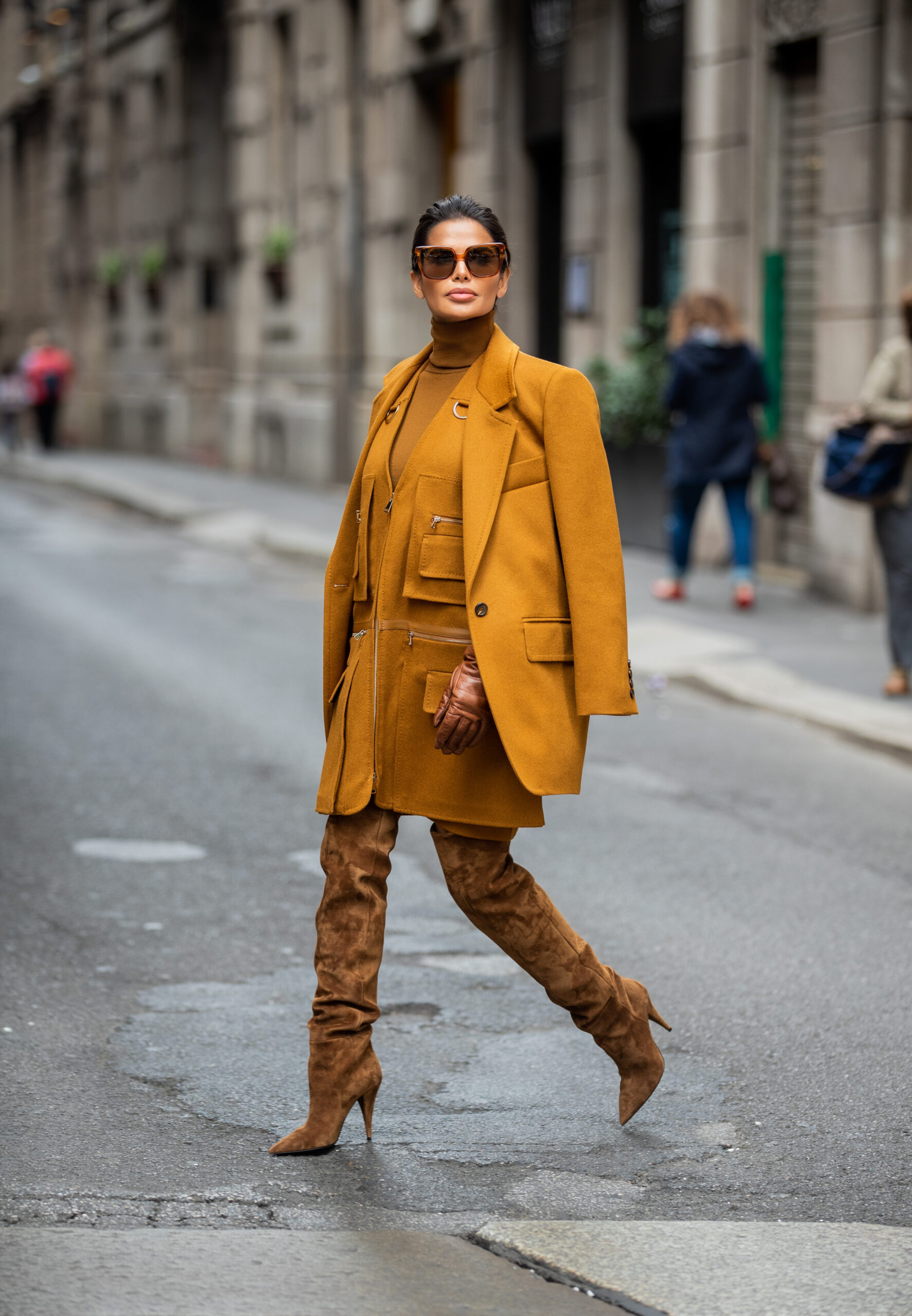 Victoria Barbara walking through Milan during Milan Fashion Week wearing a monochromatic Max Mara ensemble with Saint Laurent suede boots and Celine sunglasses.