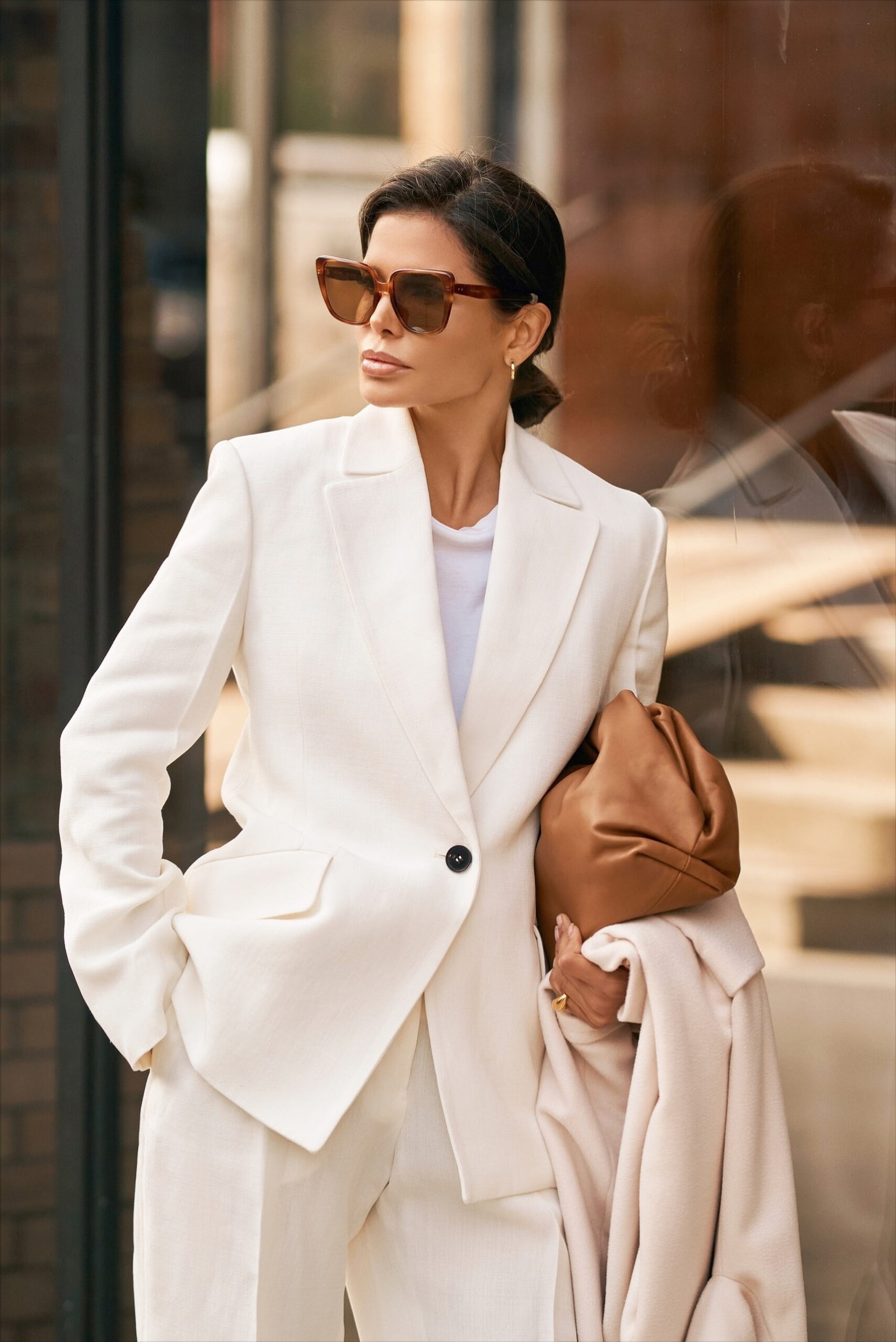 Portrait of Victoria Barbara wearing Jil Sander tailoring, Celine sunglasses, and carrying a Bottega Veneta clutch in New York City.