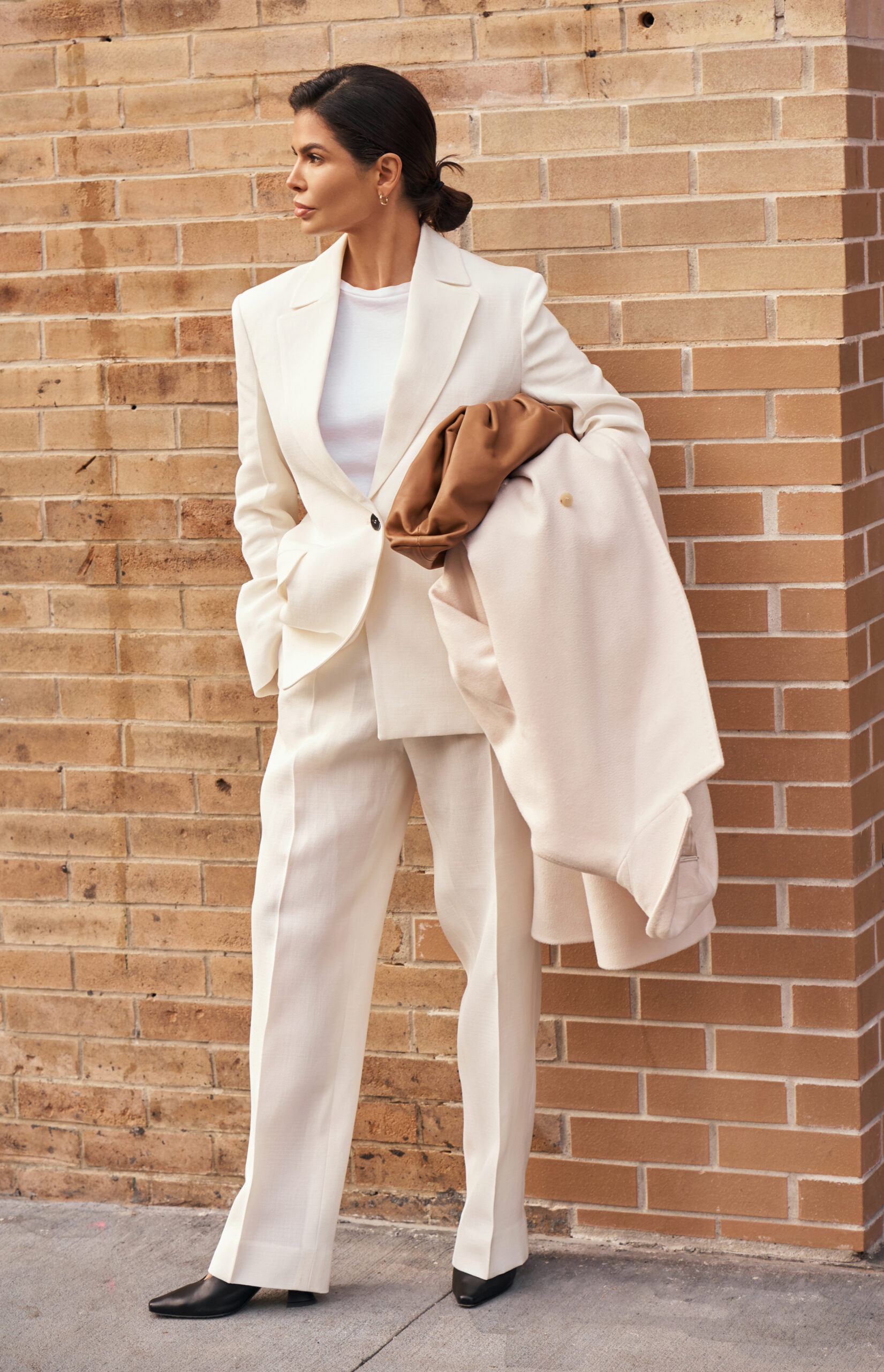 Victoria Barbara wearing an ivory Jil Sander blazer and matching trousers with a Max Mara coat and Bottega Veneta clutch in New York.