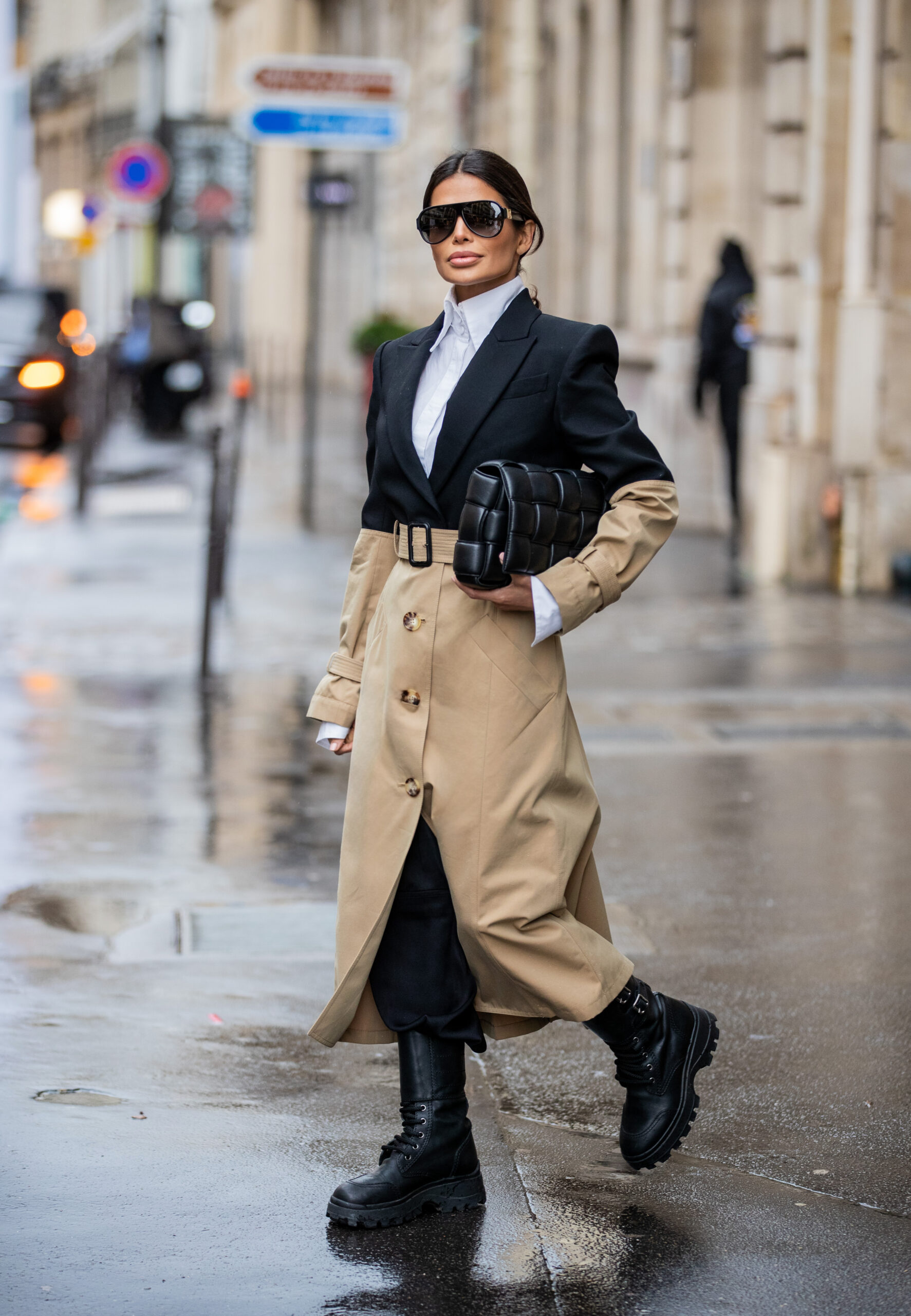 Victoria Barbara walking through Paris in a tailored trench coat and black combat boots during a rainy day at Paris Fashion Week.
