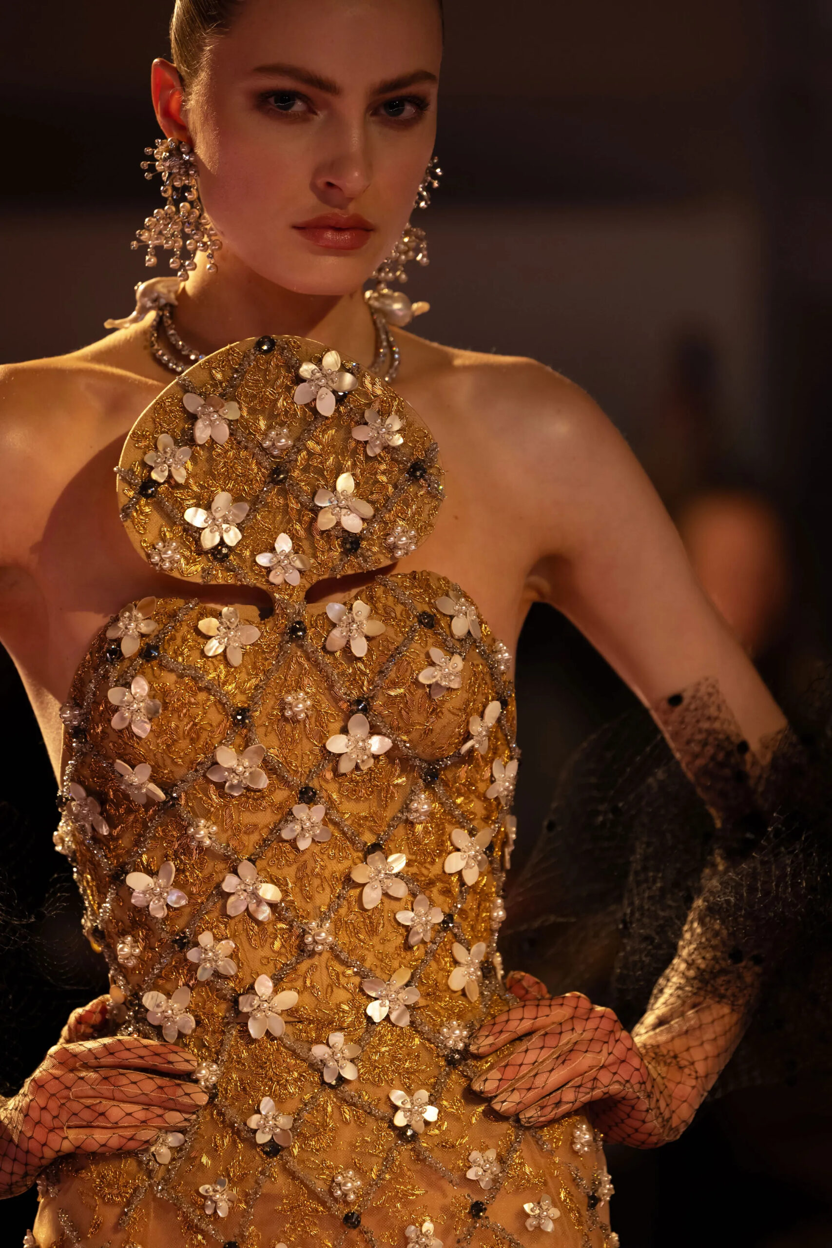 Close-up of gold embroidered Schiaparelli couture bodice with floral embellishments