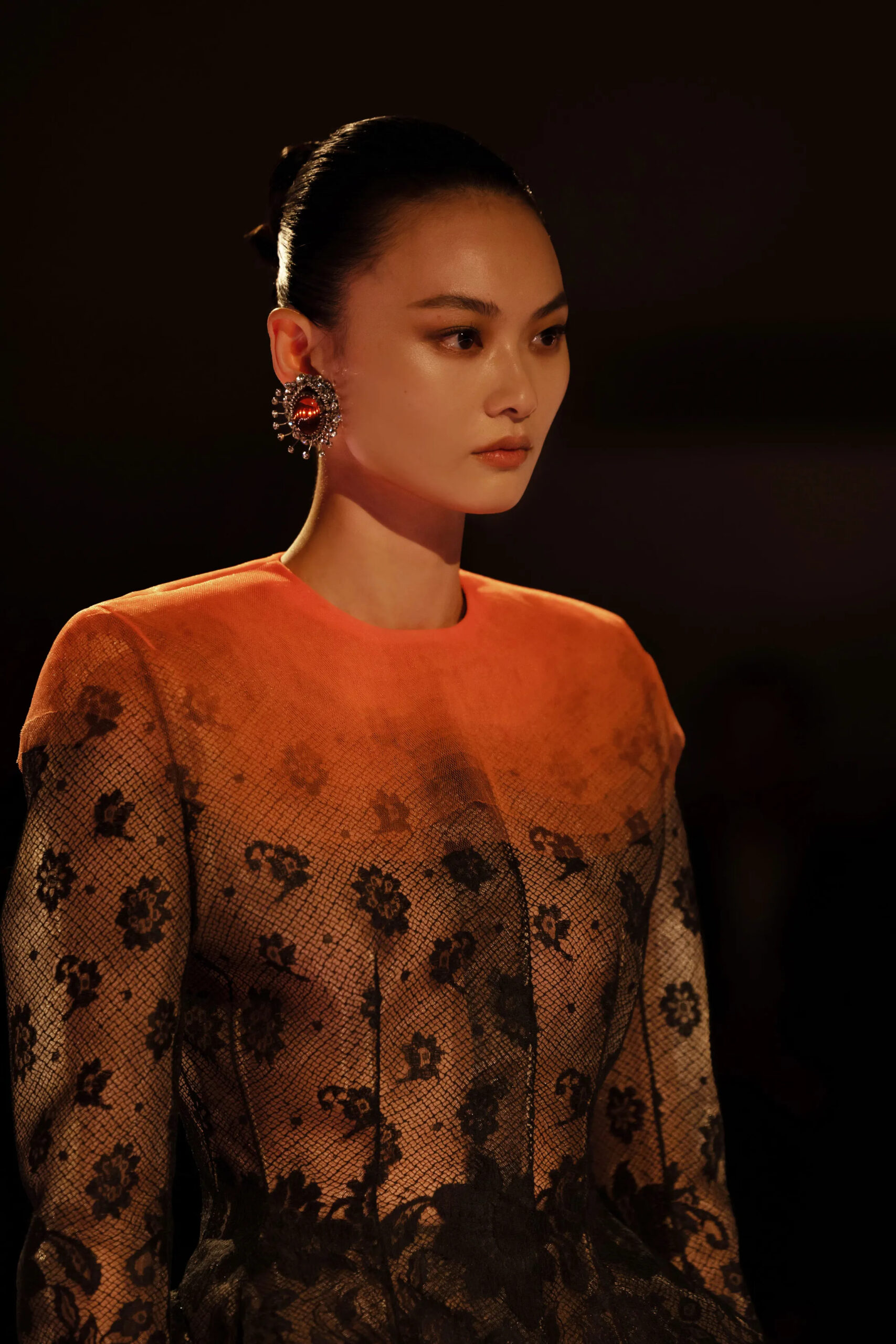Close-up portrait of black lace Schiaparelli couture look with structured silhouette