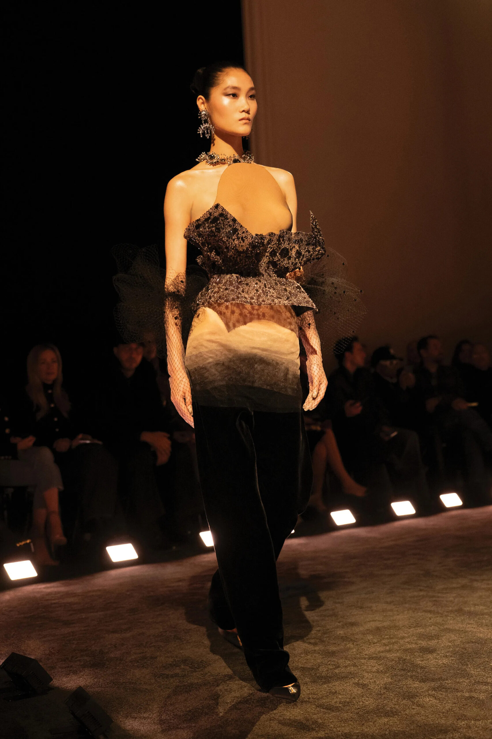 Black velvet Schiaparelli couture trousers paired with sculptural bodice and sharp tailoring